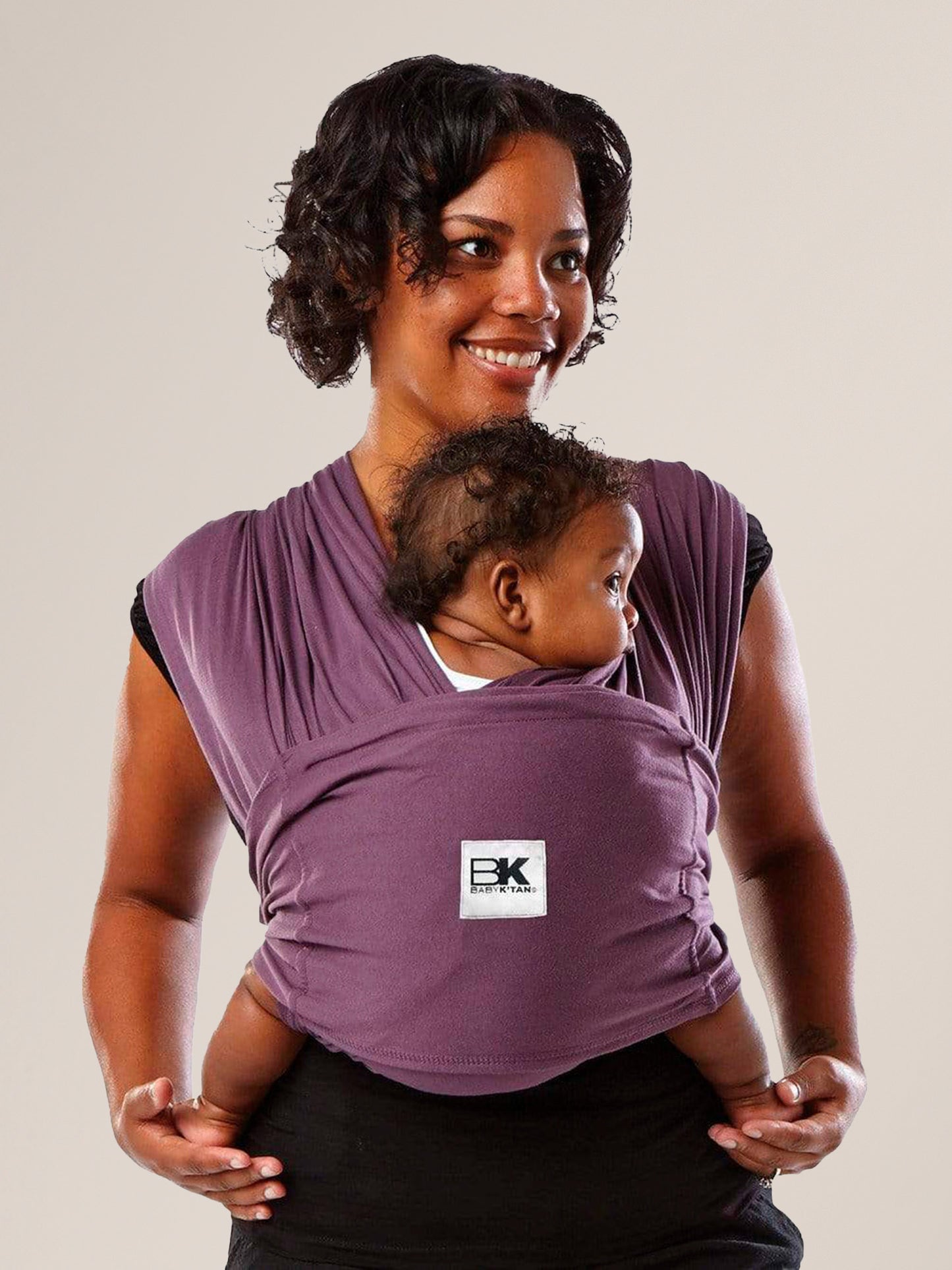 Model wearing baby in the Baby K'tan Original Baby Carrier in Eggplant