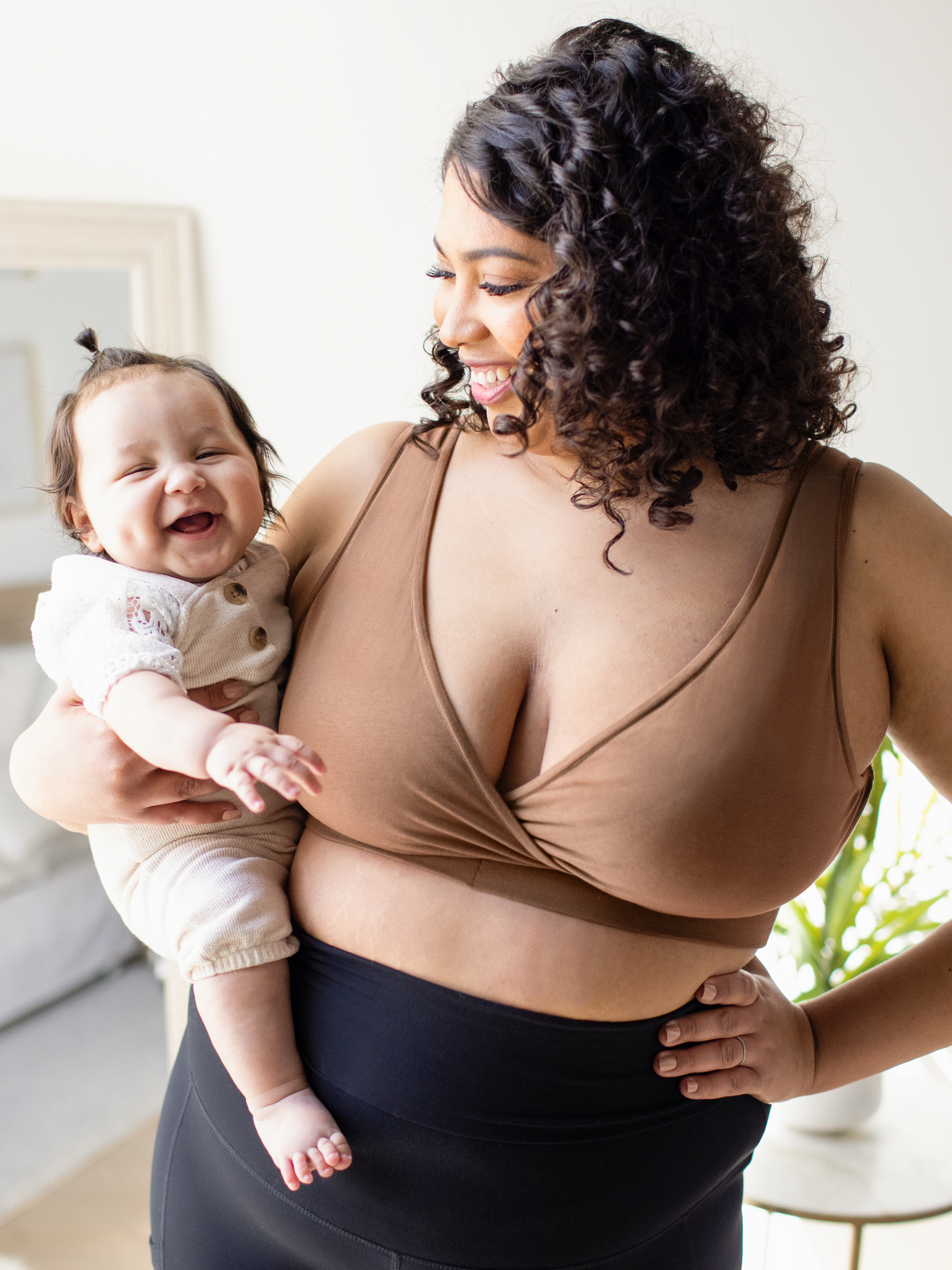 Model wearing the Organic Cotton Sleep & Nursing Bra  in Mocha, holding baby