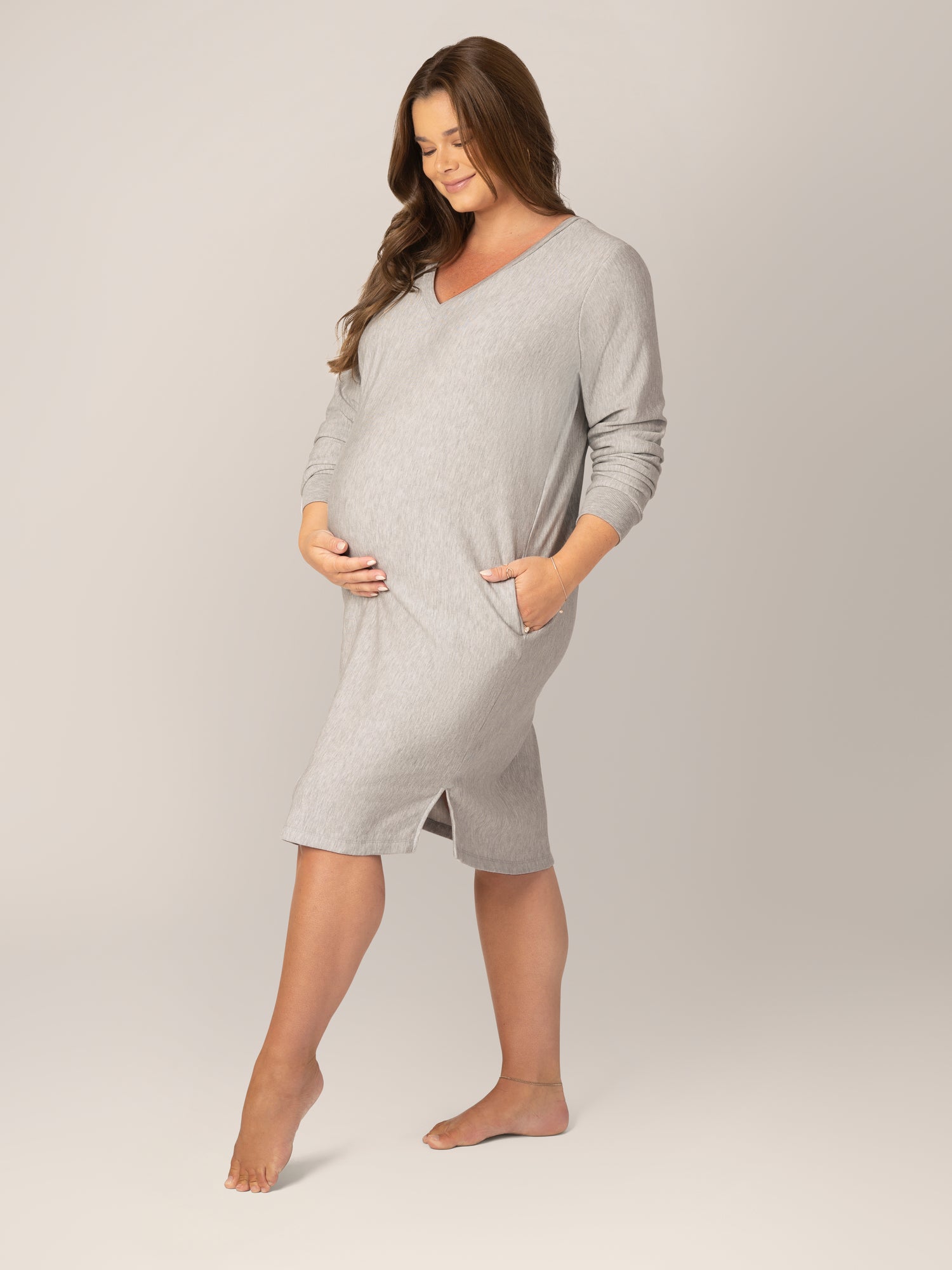 3/4 view of pregnant model wearing the Blake Oversized Maternity & Nursing Lounge Dress in Grey Heather, with one hand in pocket