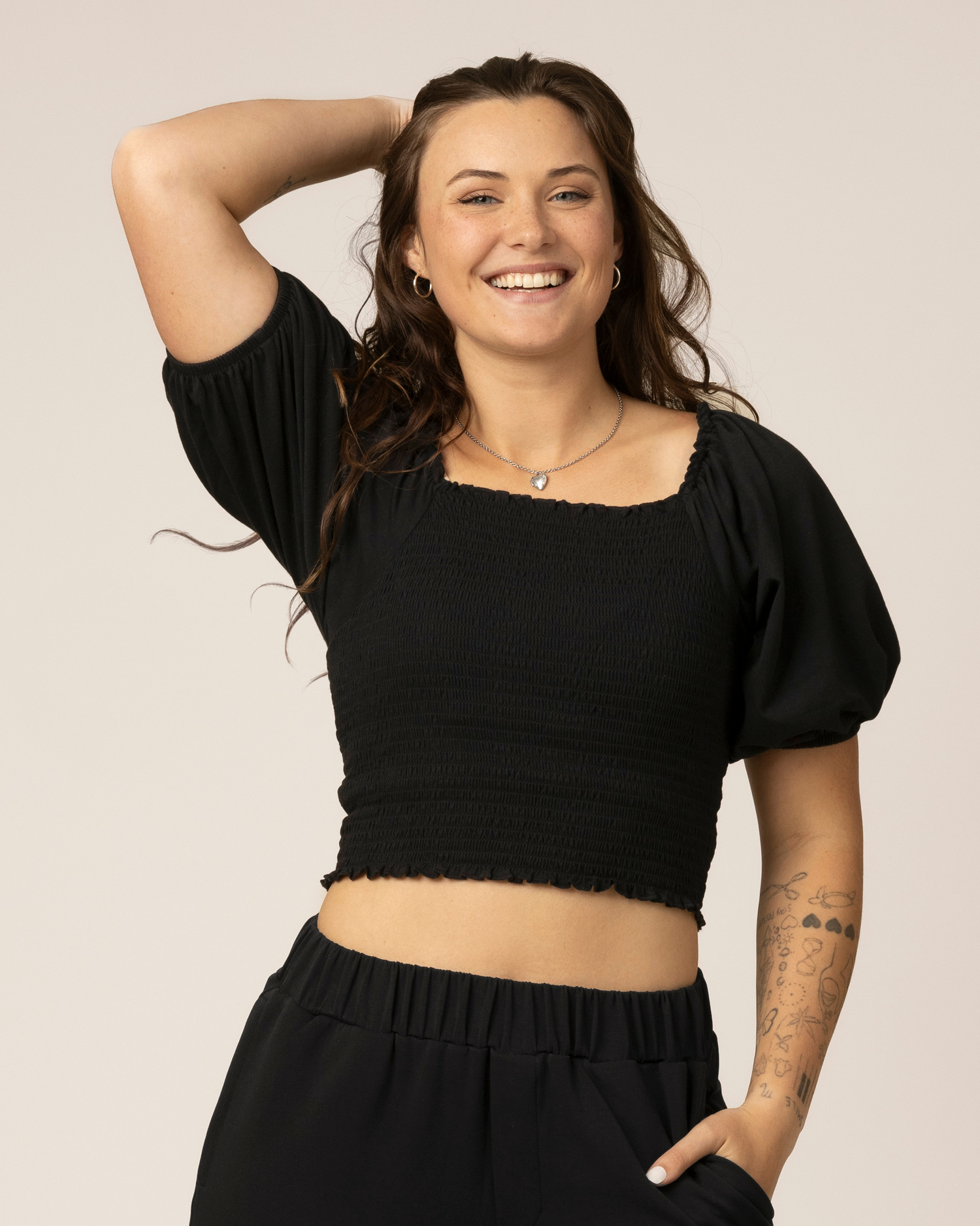 Front view of model wearing Sophia Smocked Cropped Nursing Top in Black 