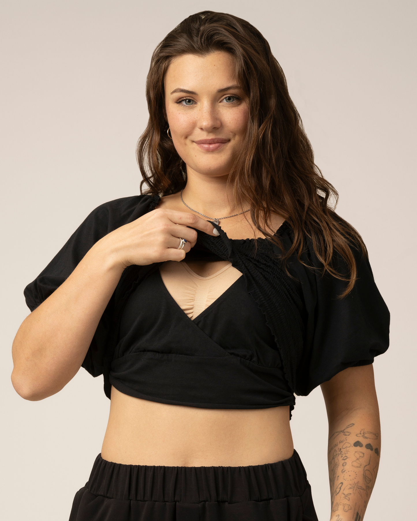 Front view of model wearing Sophia Smocked Cropped Nursing Top in Black, showing nursing access