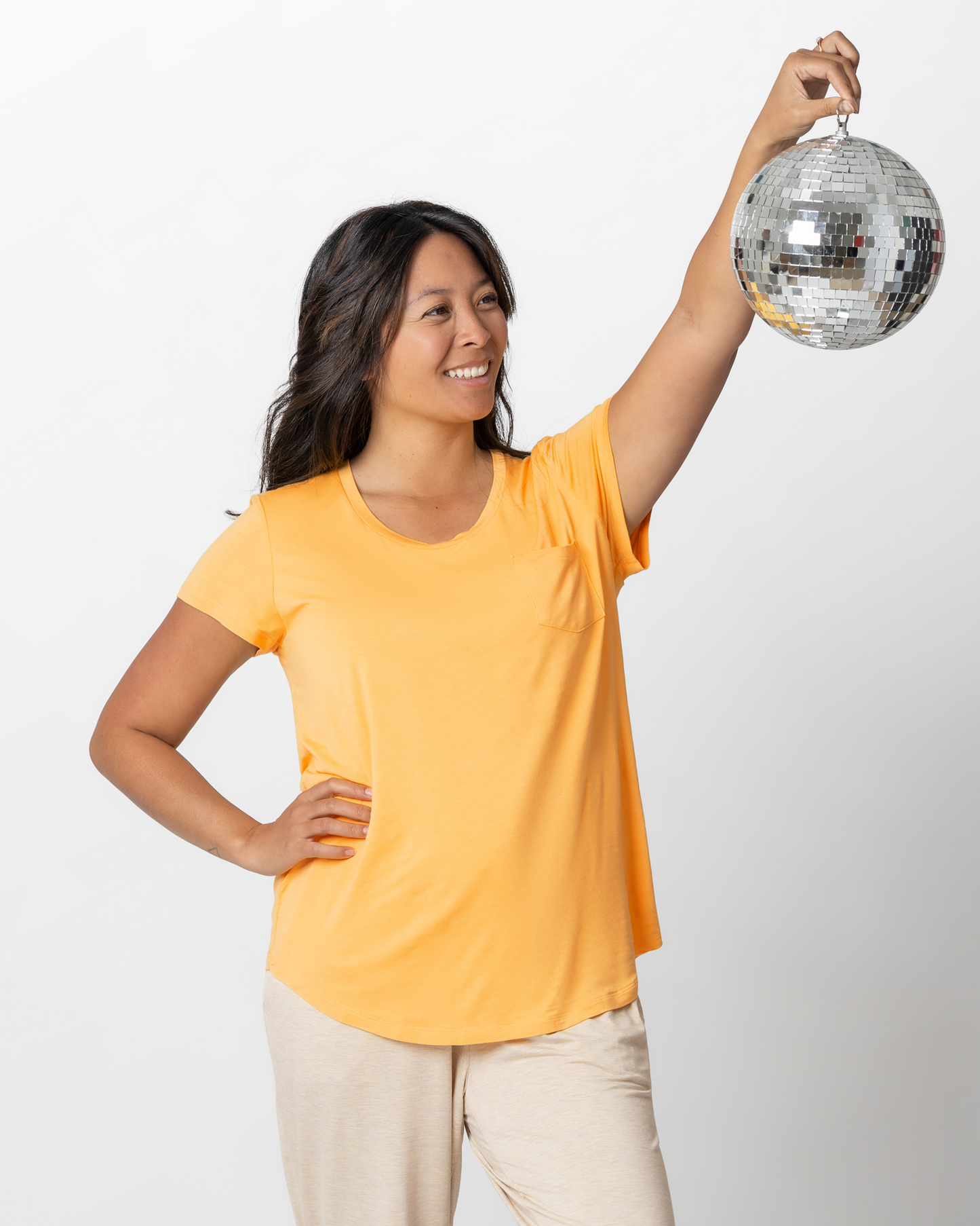 Model holding disco ball while wearing the Everyday Maternity & Nursing T-shirt in Marigold @model_info:Hillary is wearing a Medium.