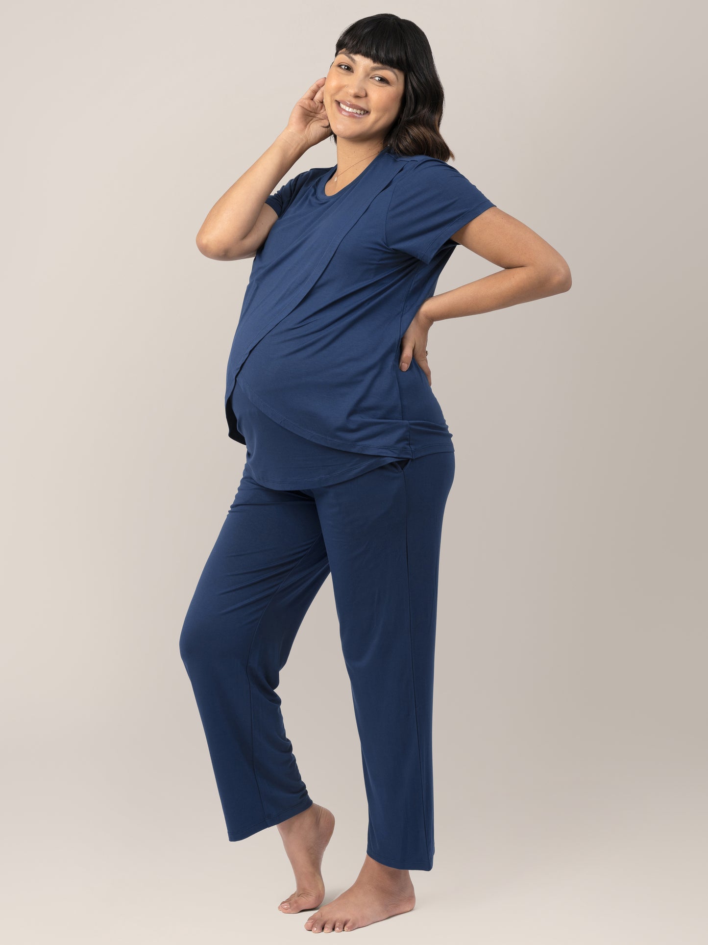 Pregnant Model wearing the Tulip Hem Maternity and Nursing Pajama Set in Navy. Side view showing her bump.