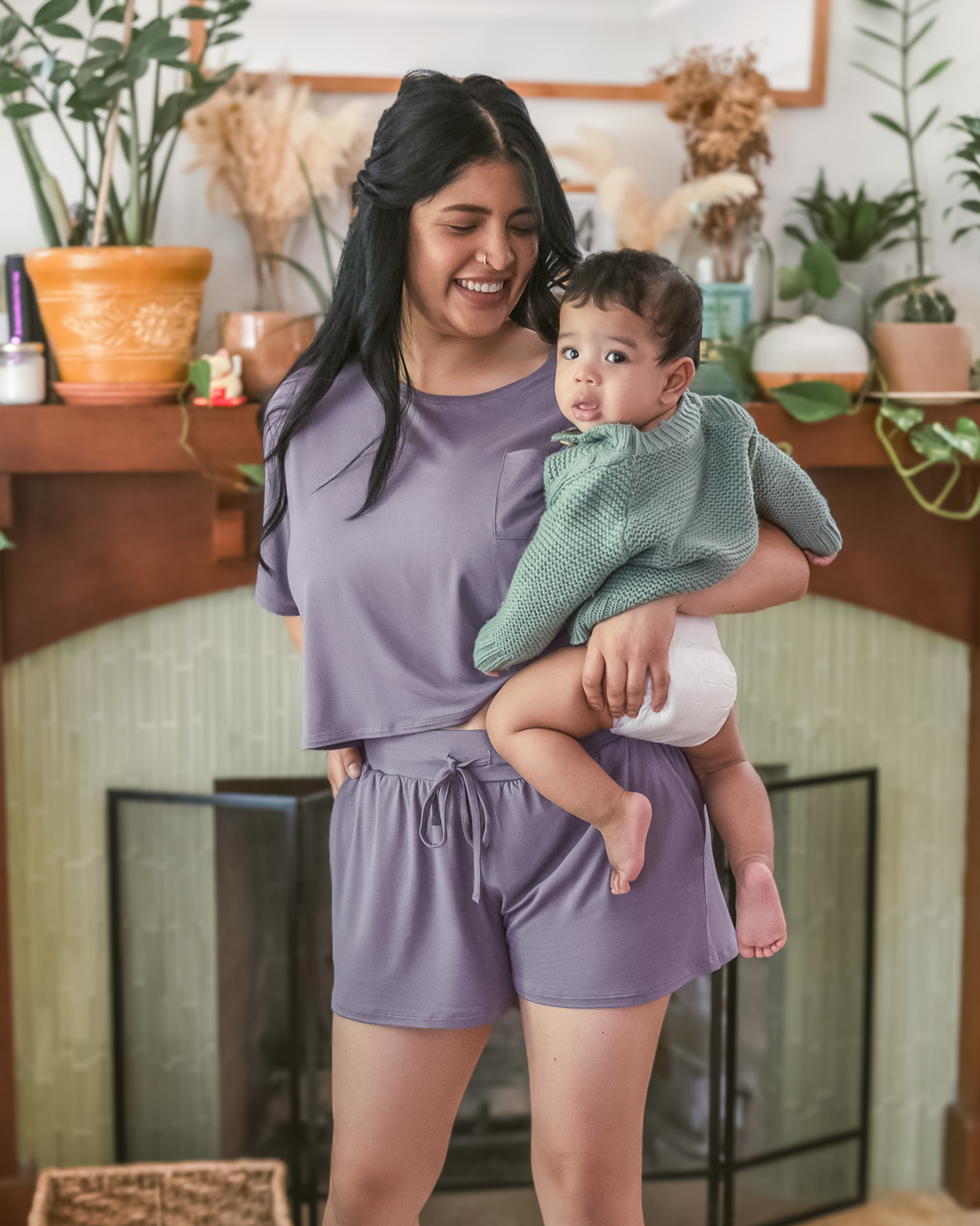 Model holding baby while wearing the Aria Bamboo Casual Cropped Short Sleeve Top in Granite paired with the matching Aria Bamboo Casual Lounge Shorts @model_info:Betsabe is wearing a Medium.