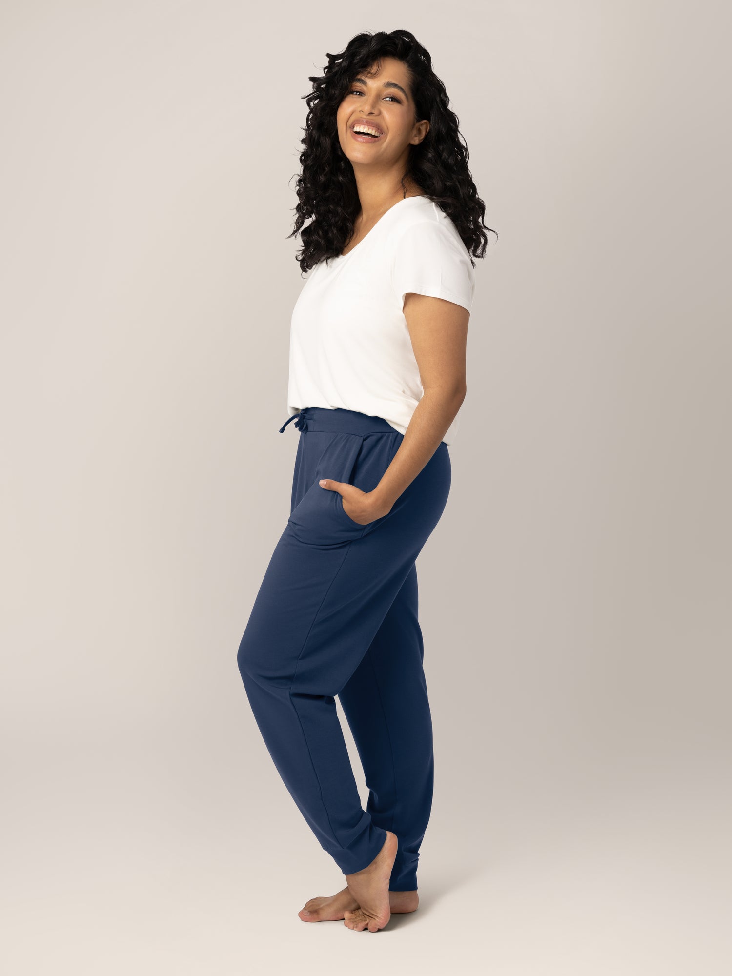 Full body side view of model wearing the Bamboo Maternity & Postpartum Jogger in Navy, paired with the Everyday Maternity and Nursing T-shirt in White.