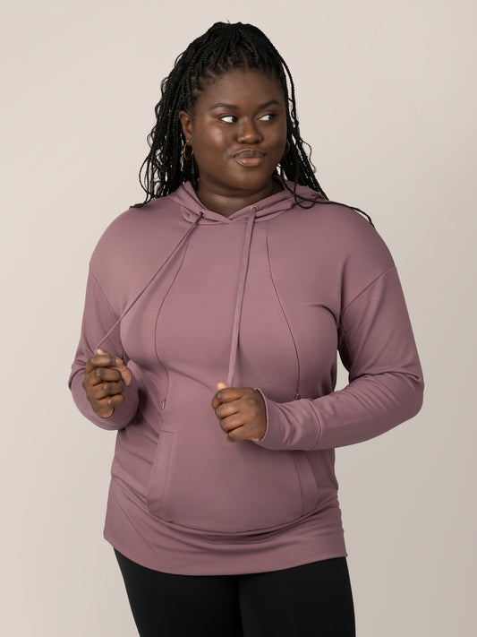 Front view of model wearing the Bamboo Maternity & Nursing Hoodie in Twilight, holding draw strings. @model_info:Bintou is wearing a Large. @model_info:Bintou is wearing an X-Large.