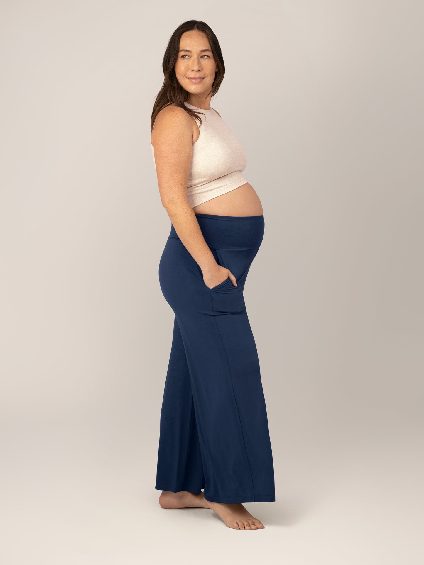 Side view of model wearing the Bamboo Wide Leg Maternity & Postpartum Lounge Pant in Navy, paired with the Sublime® Bamboo Maternity & Nursing Longline Bra in Oatmeal Heather. @model_info:Susanna is 5'7" and wearing a Small.