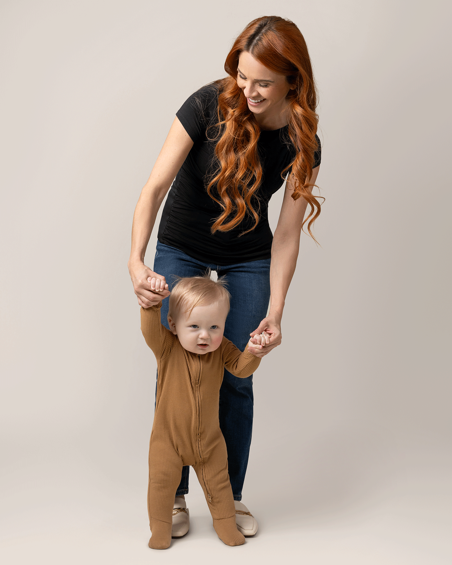 Front view of model wearing Kiera Boat Neck Maternity & Nursing Top in Black, playing with baby