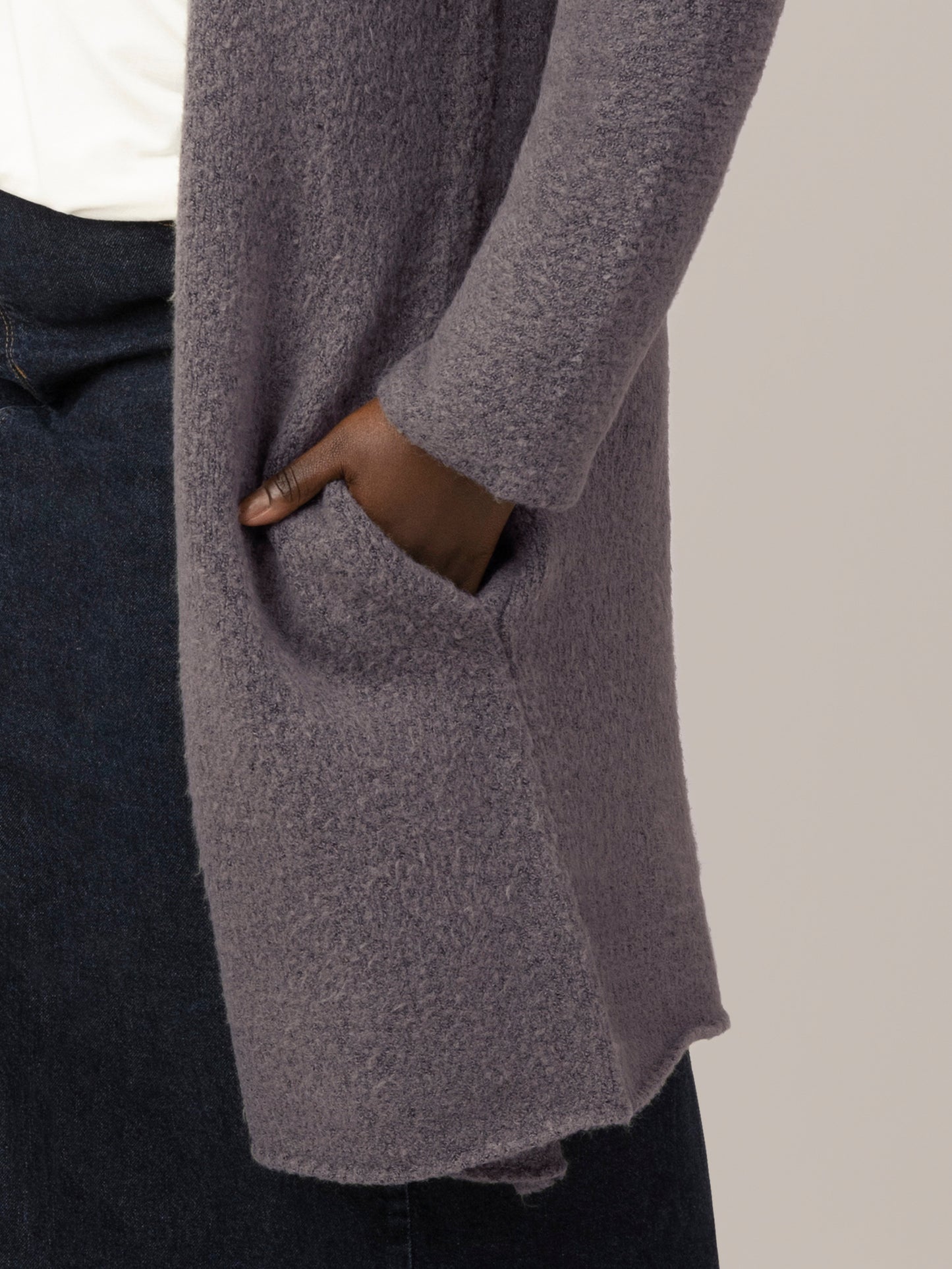 Close up view of model wearing the Chloe Cardigan Sweater in Charcoal, showing picket and hem detail