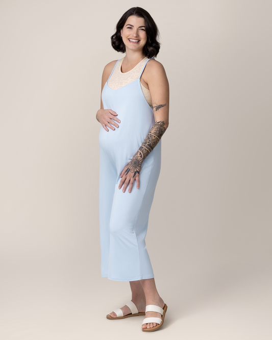 Pregnant model with hand on belly wearing the Charlie Maternity & Nursing Romper in French Blue, paired with Sublime® Bamboo Maternity & Nursing Longline Bra Top in Oatmeal Heather and flat sandals. @model_info:Emily is 5'8" and wearing a Medium.