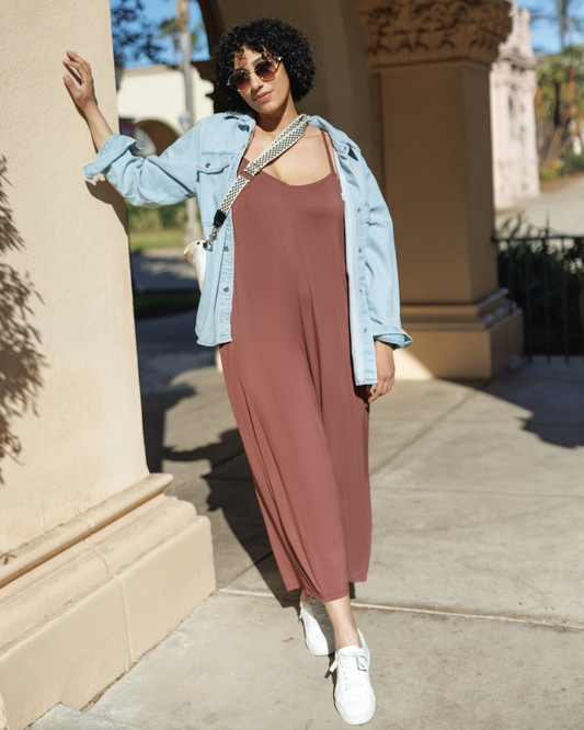 Model outside wearing the Charlie Maternity & Nursing Romper in Redwood, paired with denim jacket and white tennis shoes @model_info:Indira is 5'8" and wearing an X-Large.