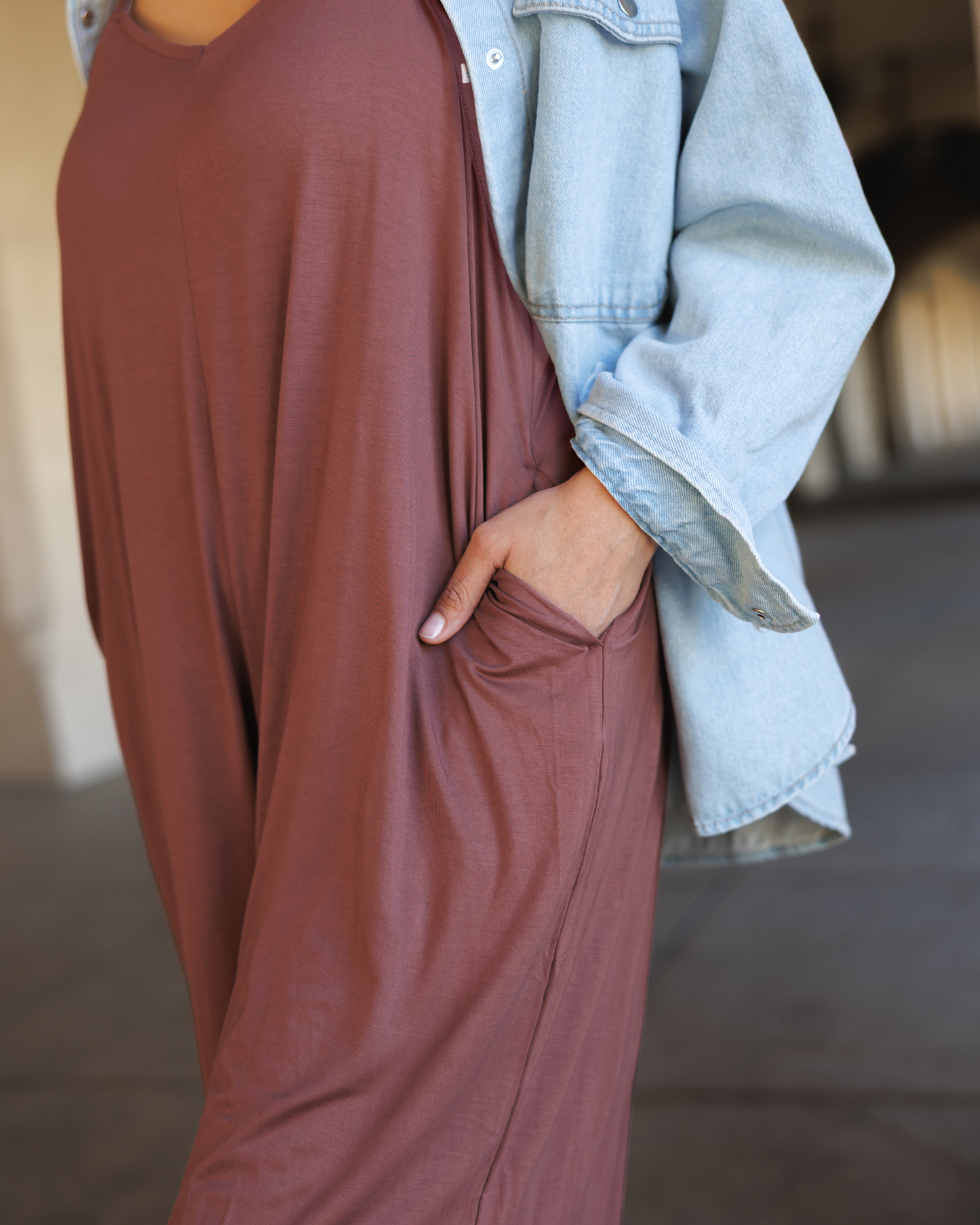 Close up of model outside wearing the Charlie Maternity & Nursing Romper in Redwood, showing fabric and pocket detail