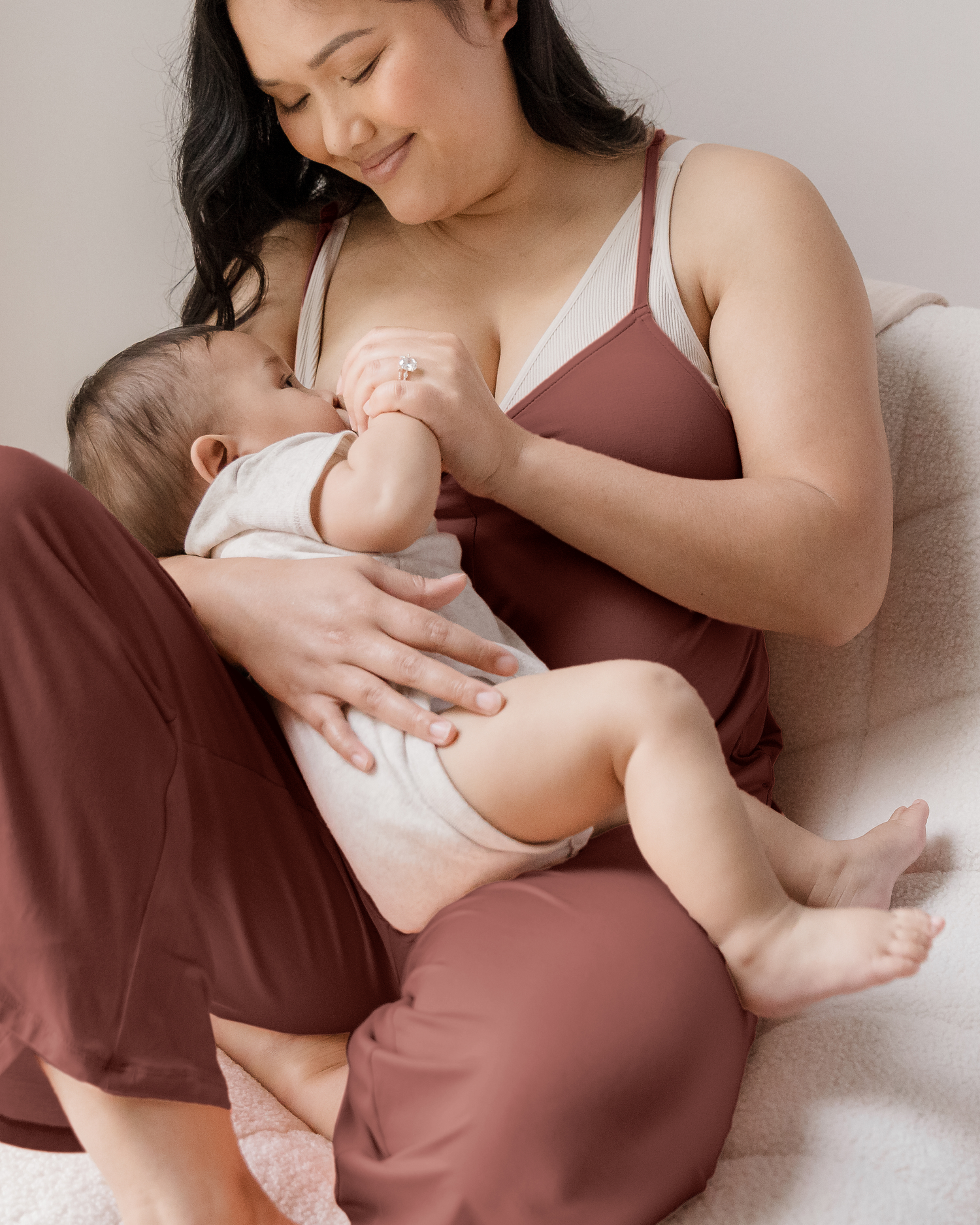 Model breastfeeding her baby while wearing the Charlie Maternity & Nursing Romper in Redwood @model_info:Binc is 5'5" and wearing a Medium.