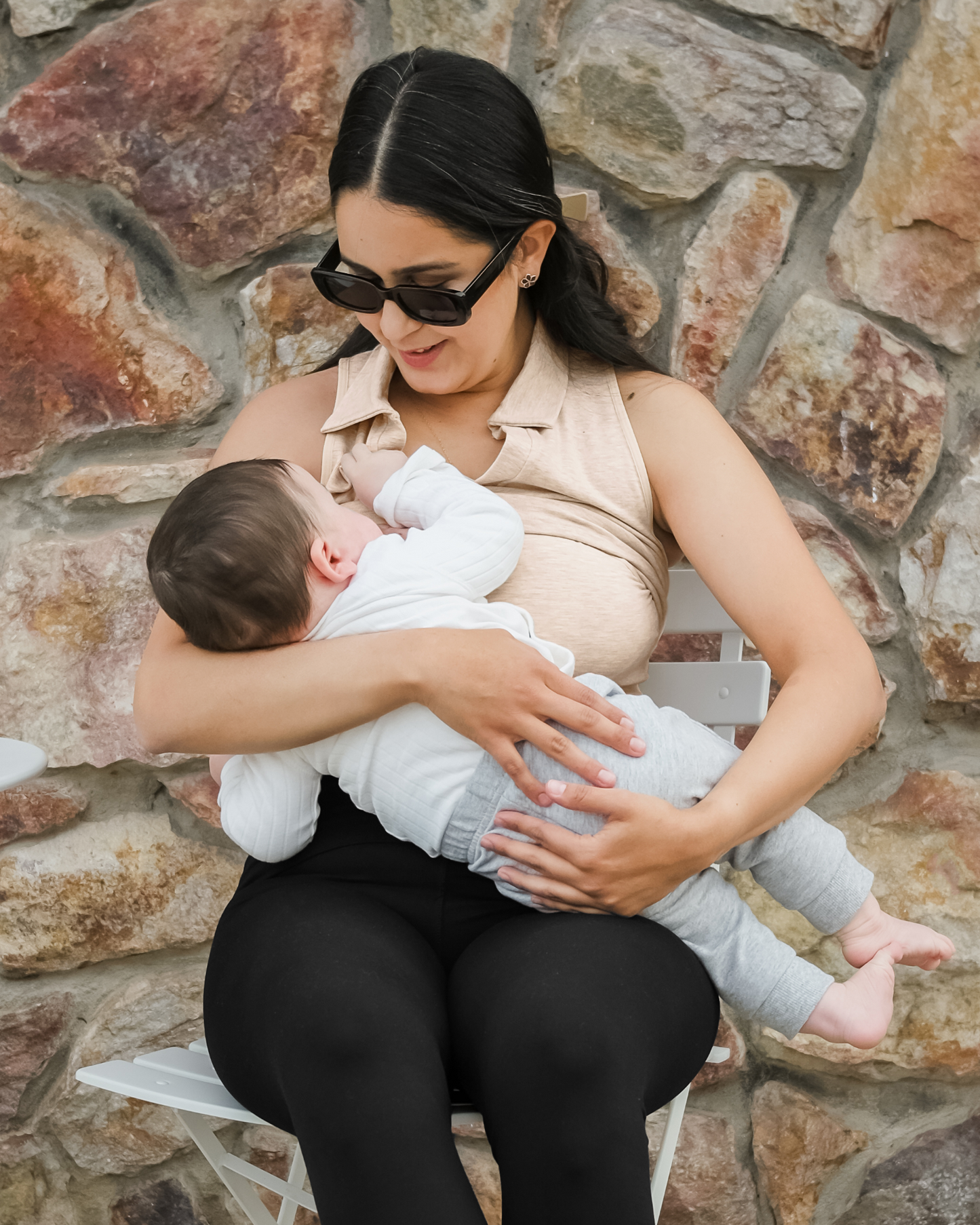 Model sitting outside nursing baby and wearing the Sublime® Bamboo Collared Maternity & Nursing Longline Bra Top in Oatmeal Heather, paired with the Louisa Legging@model_info:Dama is wearing a Medium Busty.