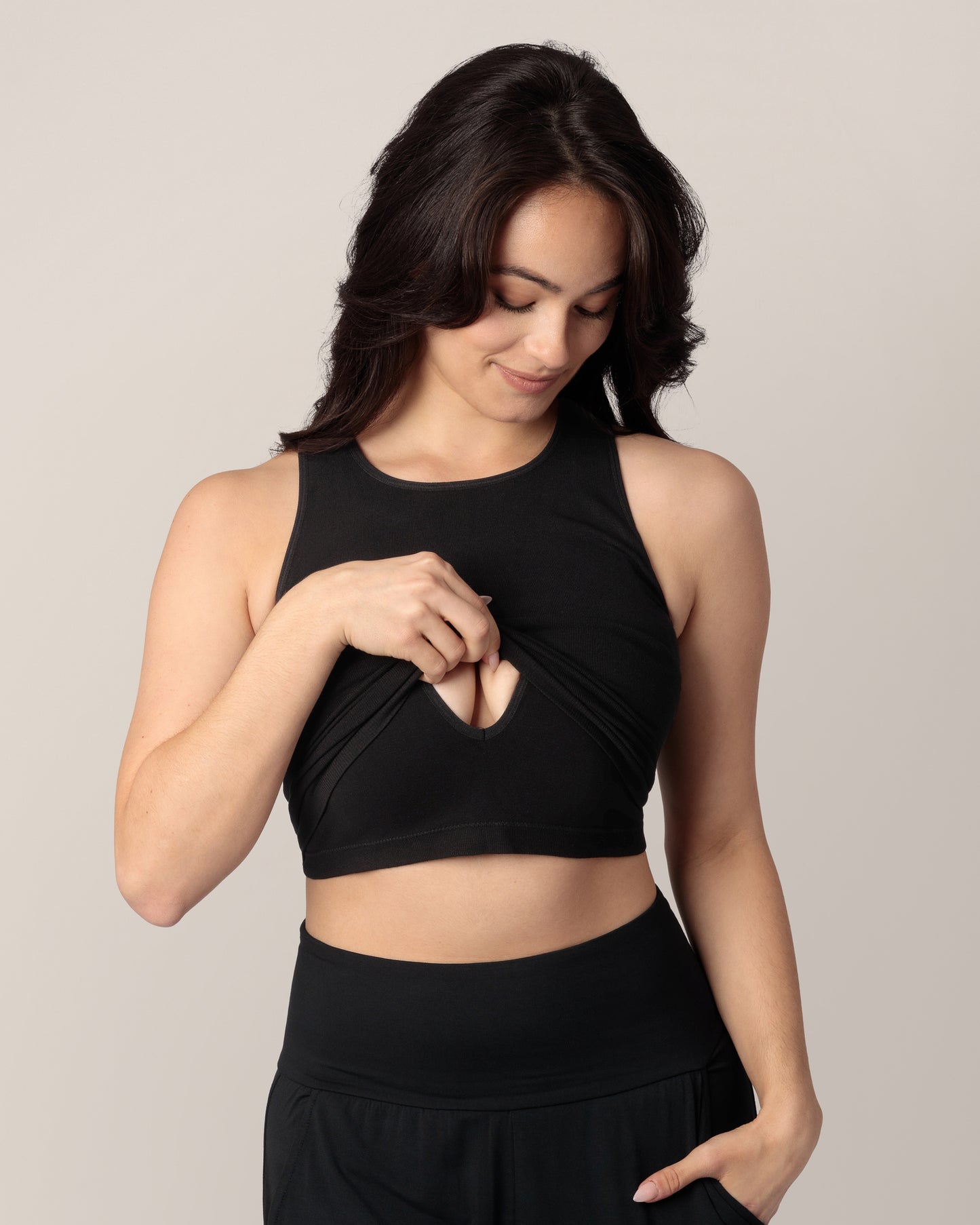 Model wearing the Sublime Bamboo Maternity & Nursing Longline Bra in Black, lifting outer layer to show nursing access.