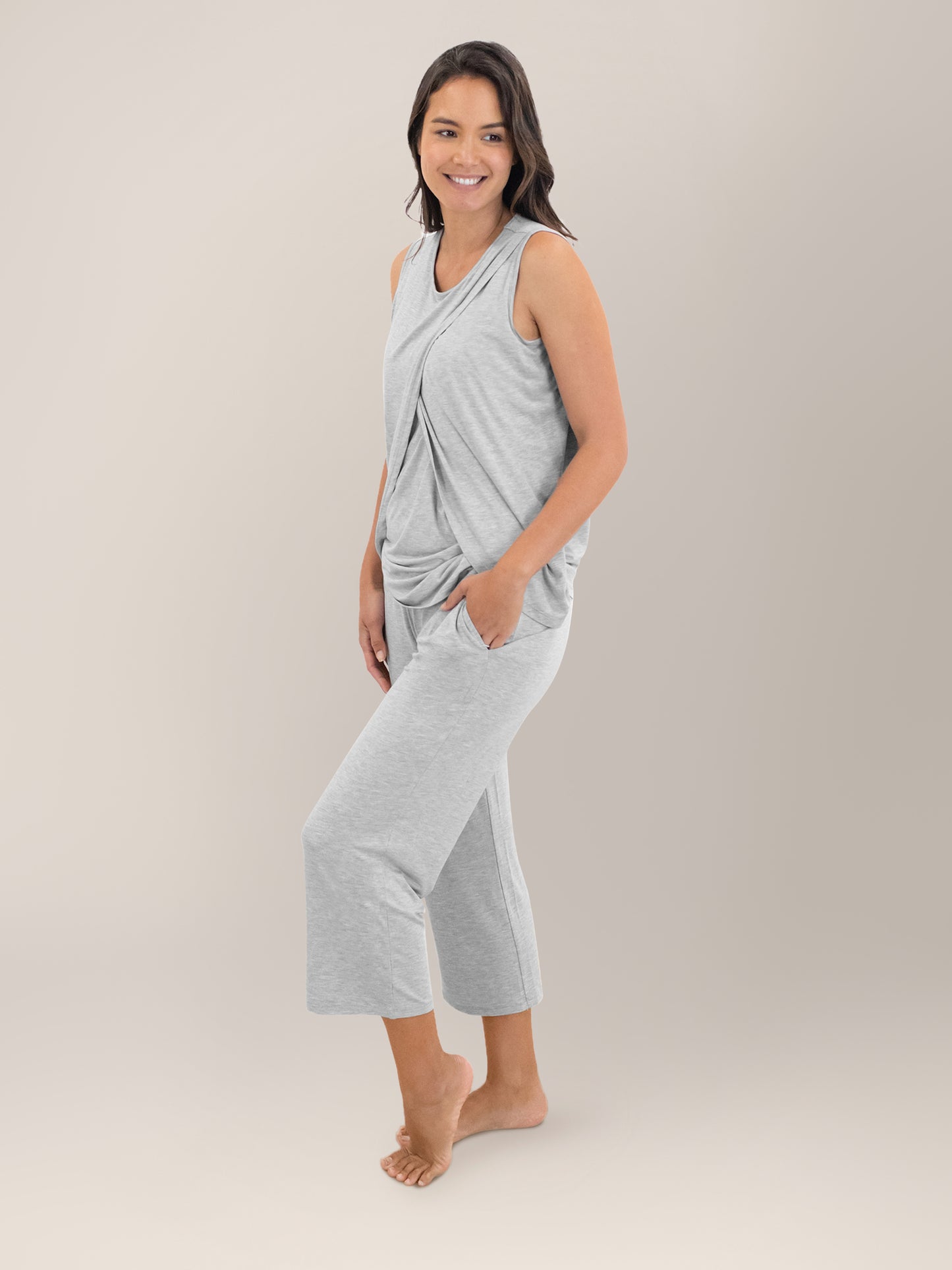 Full body side view of model wearing the Tulip Hem Nursing Tank & Capri Pajama Set in Grey Heather, with one hand in pocket.