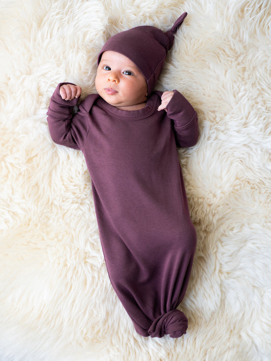 Baby wearing the Baby Knotted Gown & Hat Set in Burgundy Plum