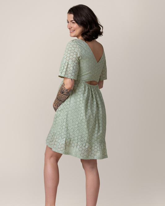 Angled back view of model wearing the Dahlia Eyelet Maternity & Nursing Dress in Aqua Mist, showing cutout in the back@model_info:Emily is 5'8" and wearing a Medium.