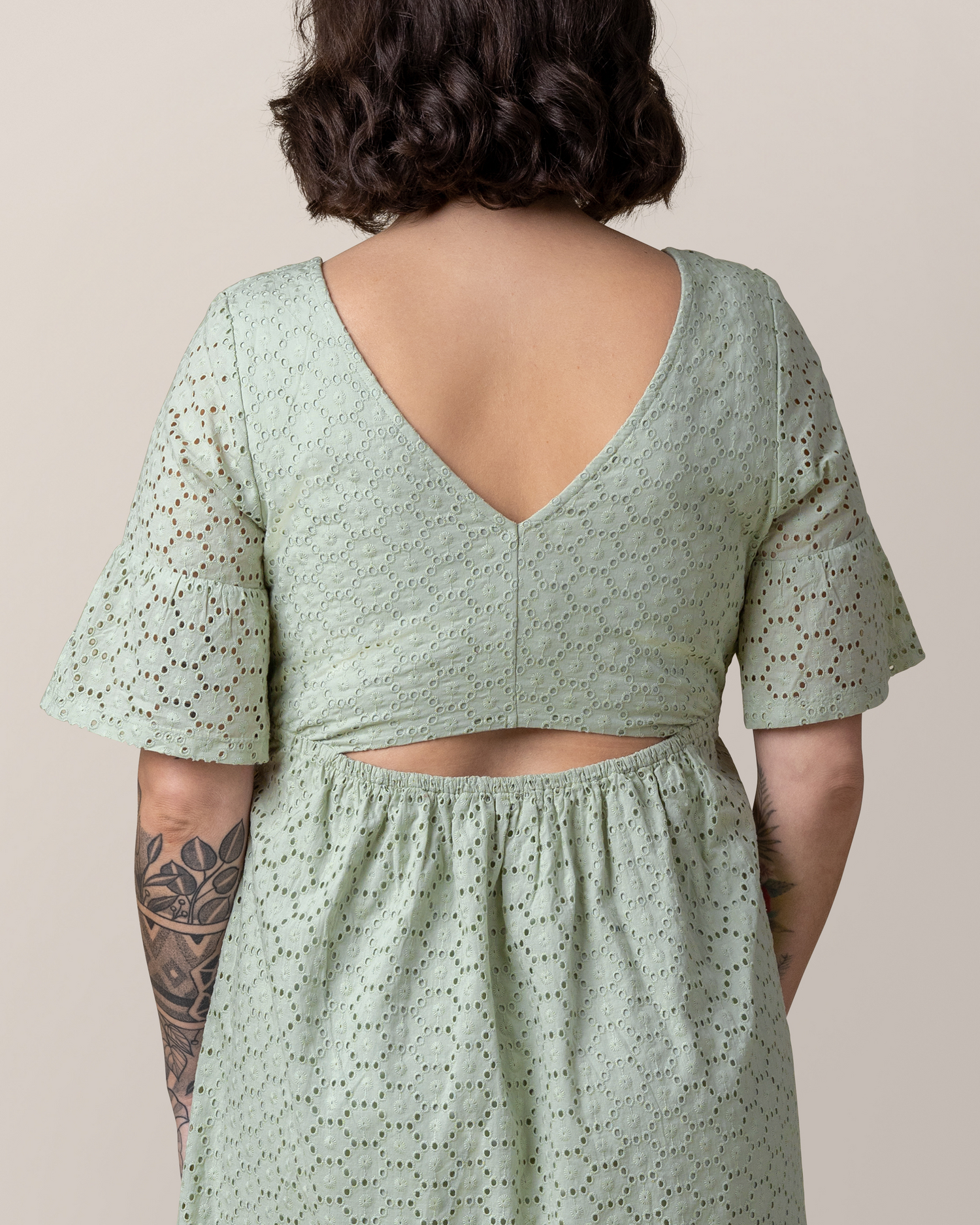 Cropped in back view of model wearing the Dahlia Eyelet Maternity & Nursing Dress in Aqua Mist, showing keyhole cutout detail