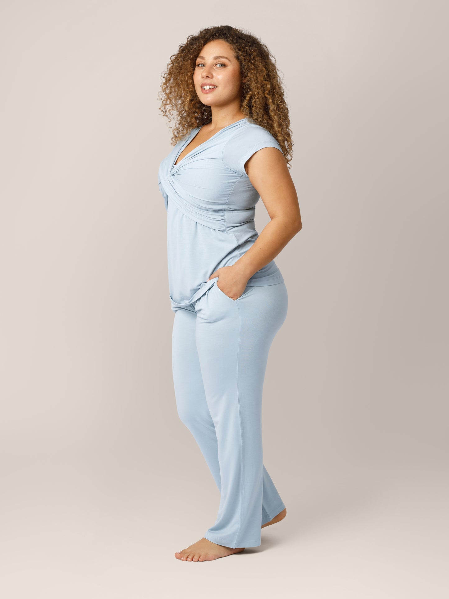 Side view of model wearing the Davy Maternity & Nursing Pajama Set in Mist, with hands in pockets.