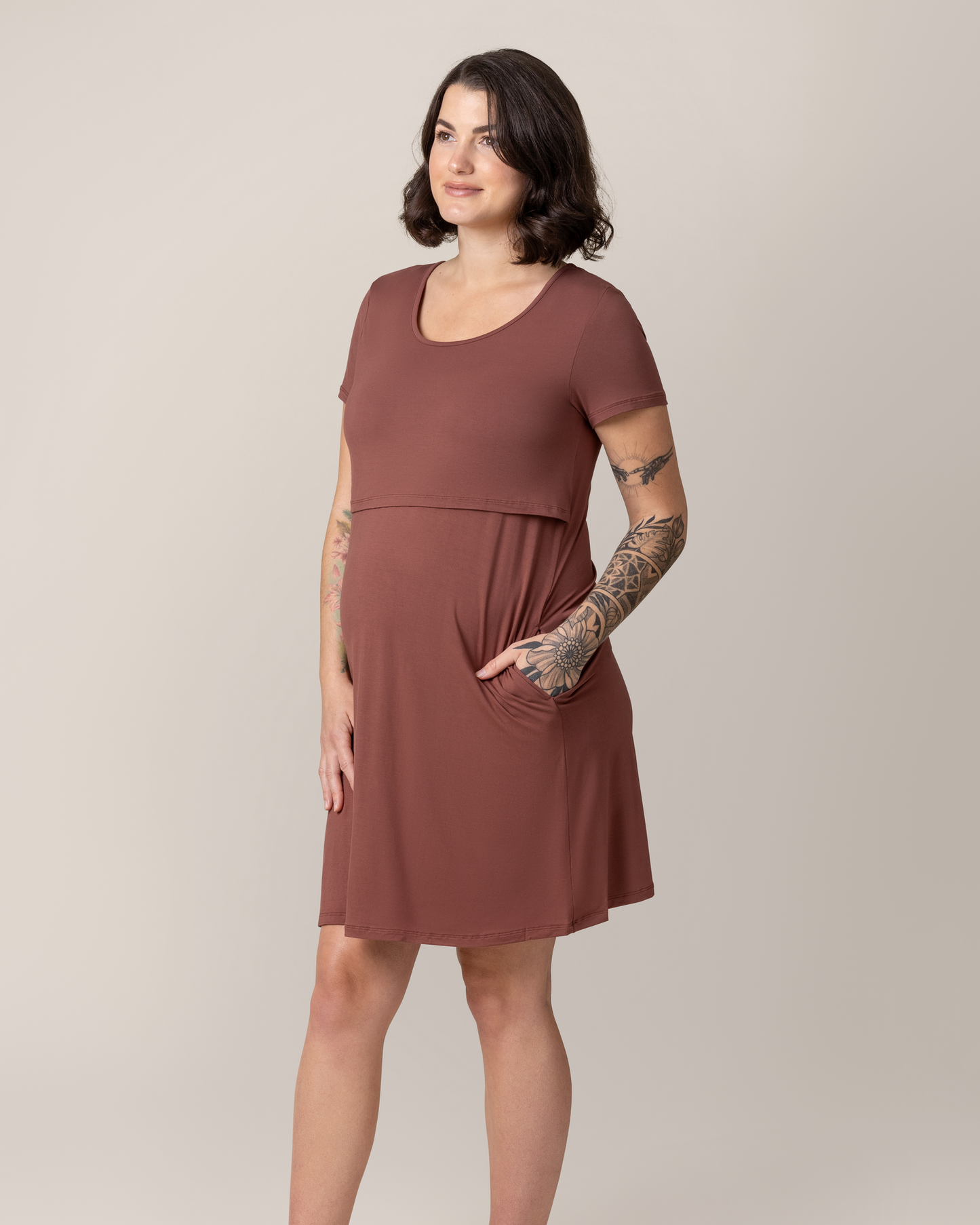 Model wearing the Eleanora Bamboo Maternity & Nursing Dress in Redwood, with hand in pocket @model_info:Emily is 5'8" and wearing a Medium.