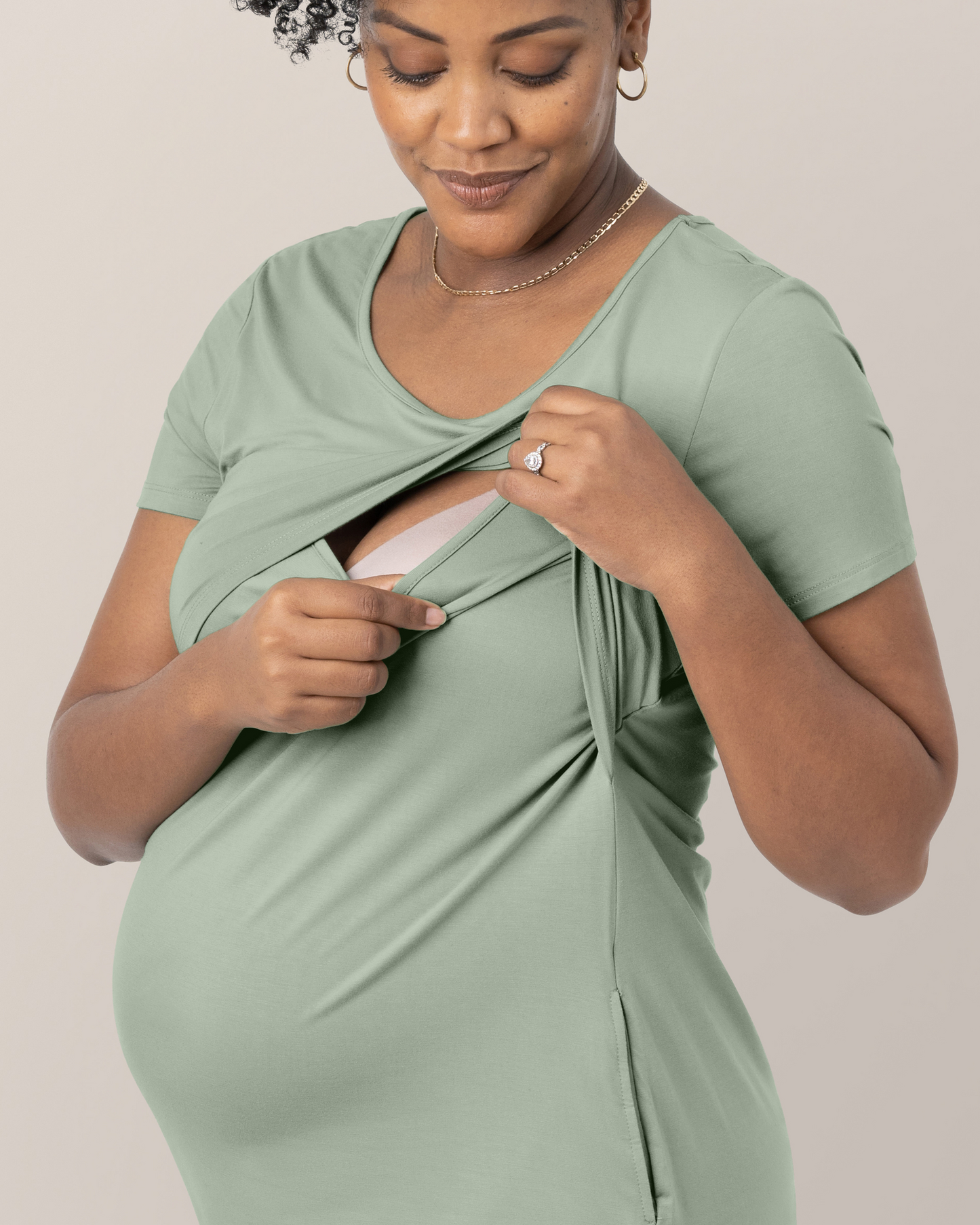 Cropped in image of model wearing the Eleanora Bamboo Maternity & Nursing Dress in Aqua Mist, lifting top outer layer to show nursing access