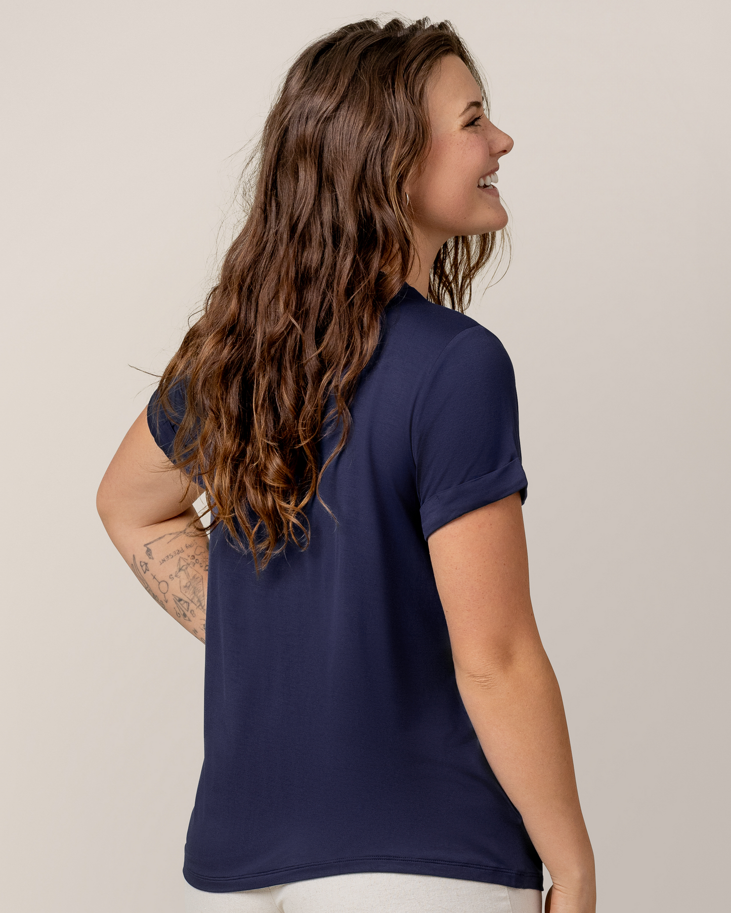 3/4 back view of model wearing the Everyday Asymmetrical Nursing T-shirt in Navy