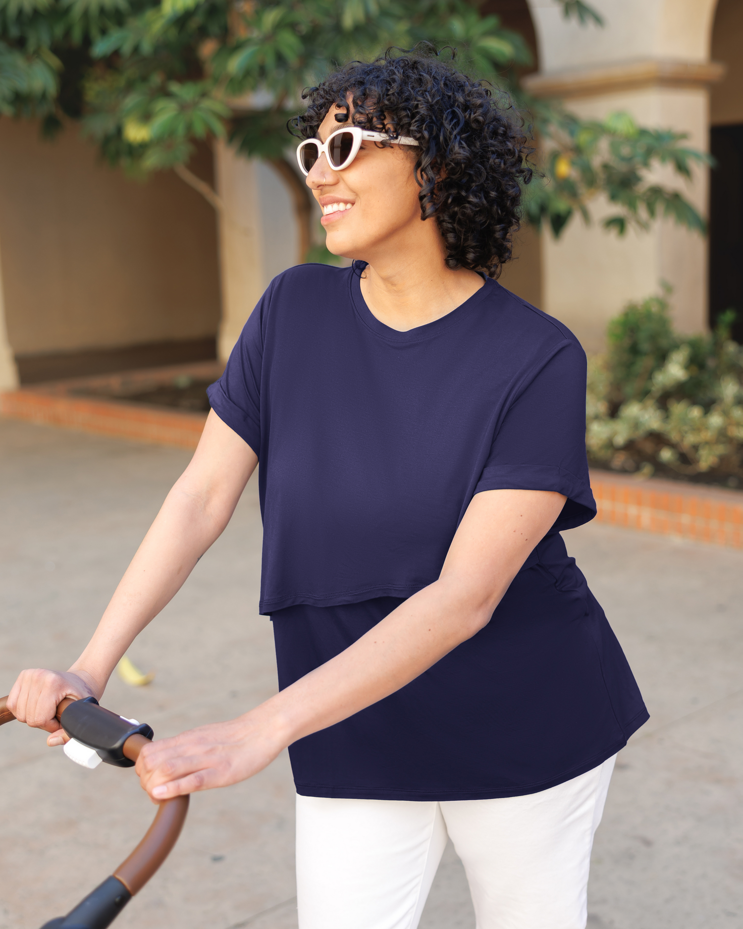 Model wearing the Everyday Asymmetrical Nursing T-shirt in Navy and pushing stroller@model_info:Indira is wearing an X-Large.