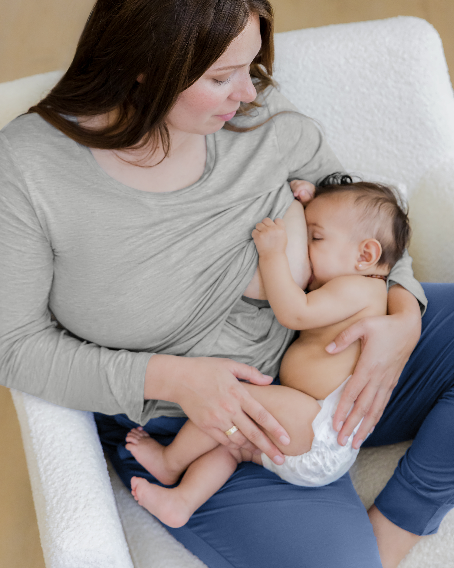 Model wearing the Bamboo Long Sleeve Nursing T-shirt in Grey Heather paired with Everyday Lounge Jogger in Slate Blue, nursing baby