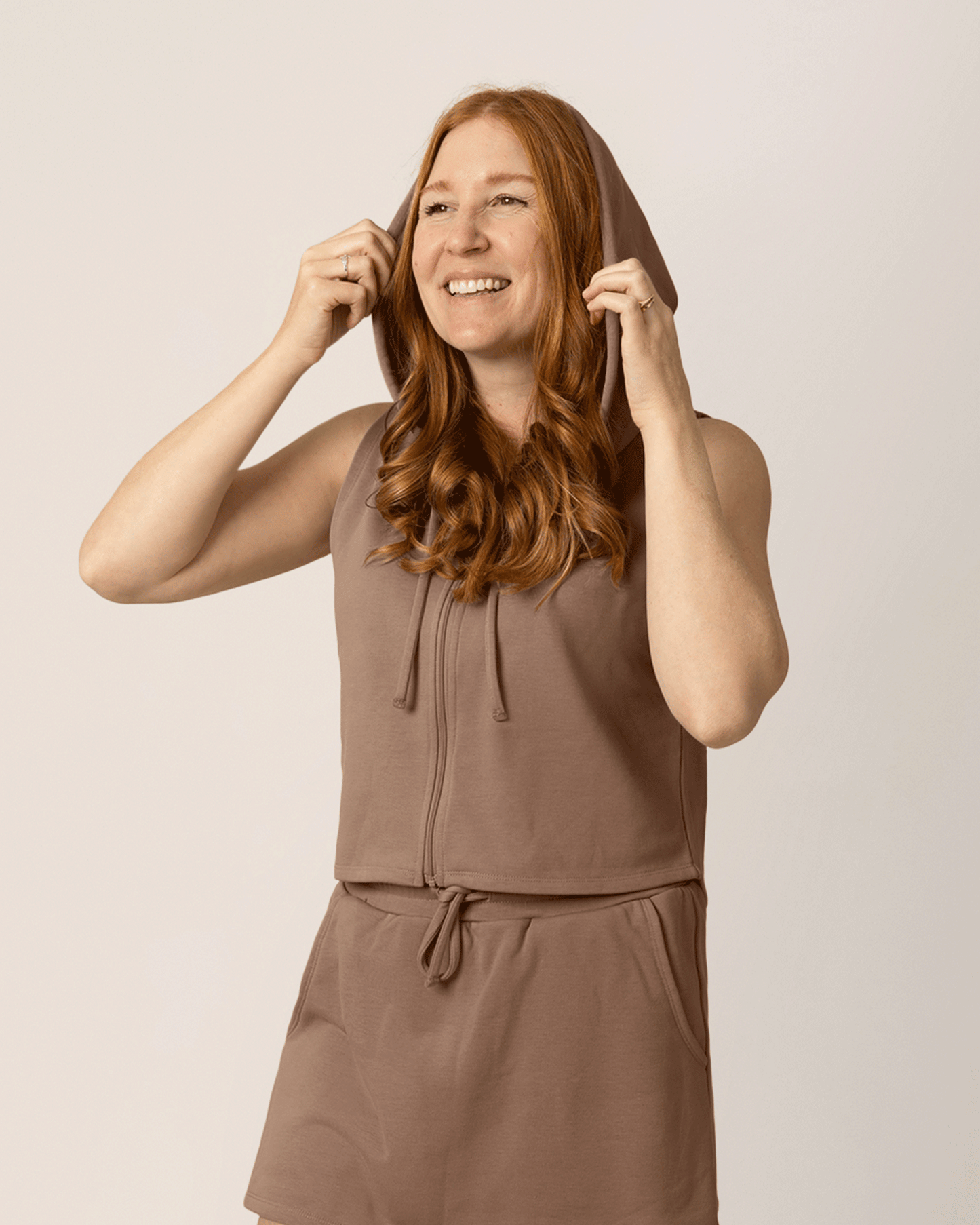 Front view of model wearing French Terry Sleeveless Nursing Hoodie in Taupe with matching French Terry On the Go Skort @model_info:Anna is wearing a Medium.