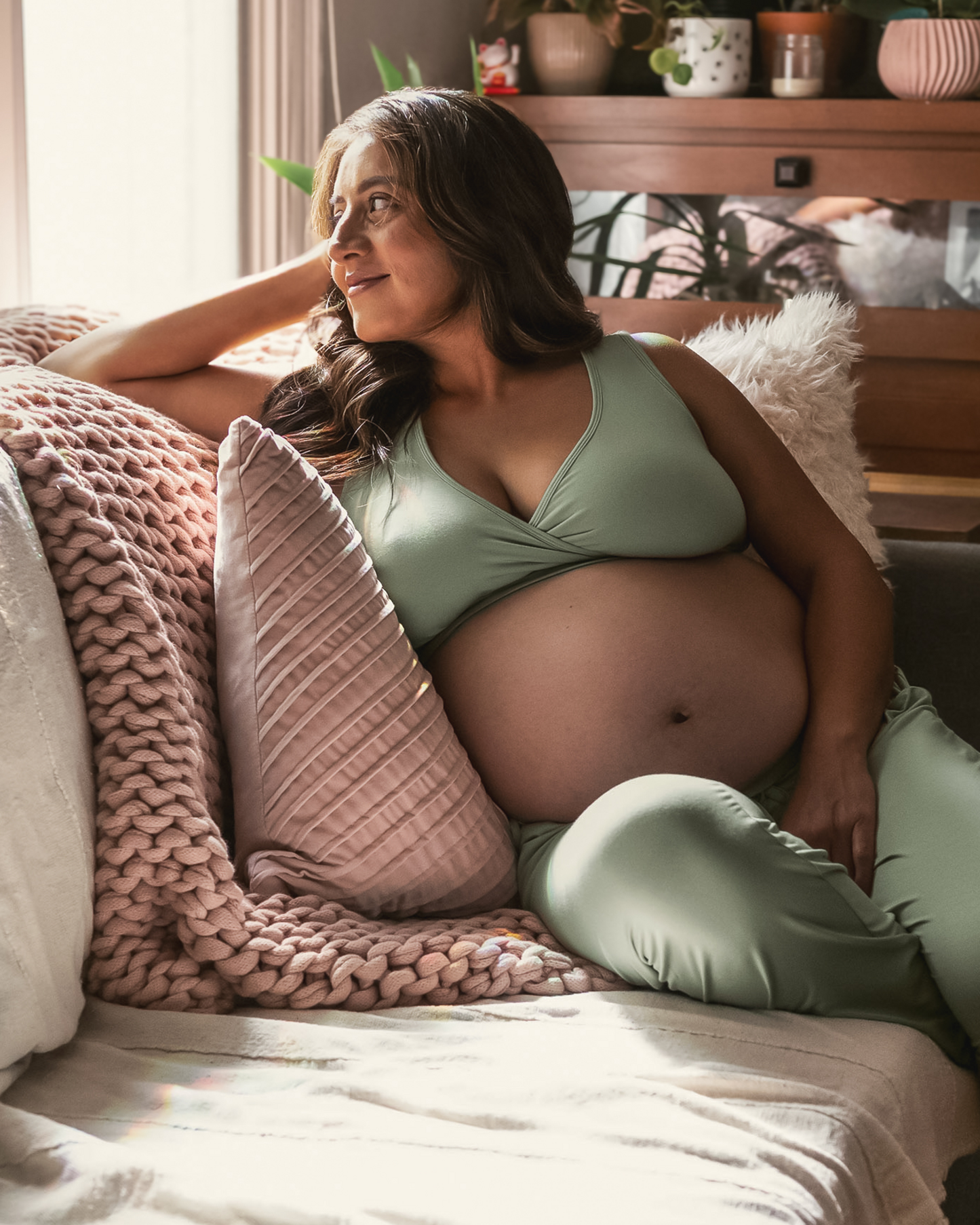 Pregnant model sitting on sofa and wearing the French Terry Racerback Nursing & Sleep Bra in Aqua Mist