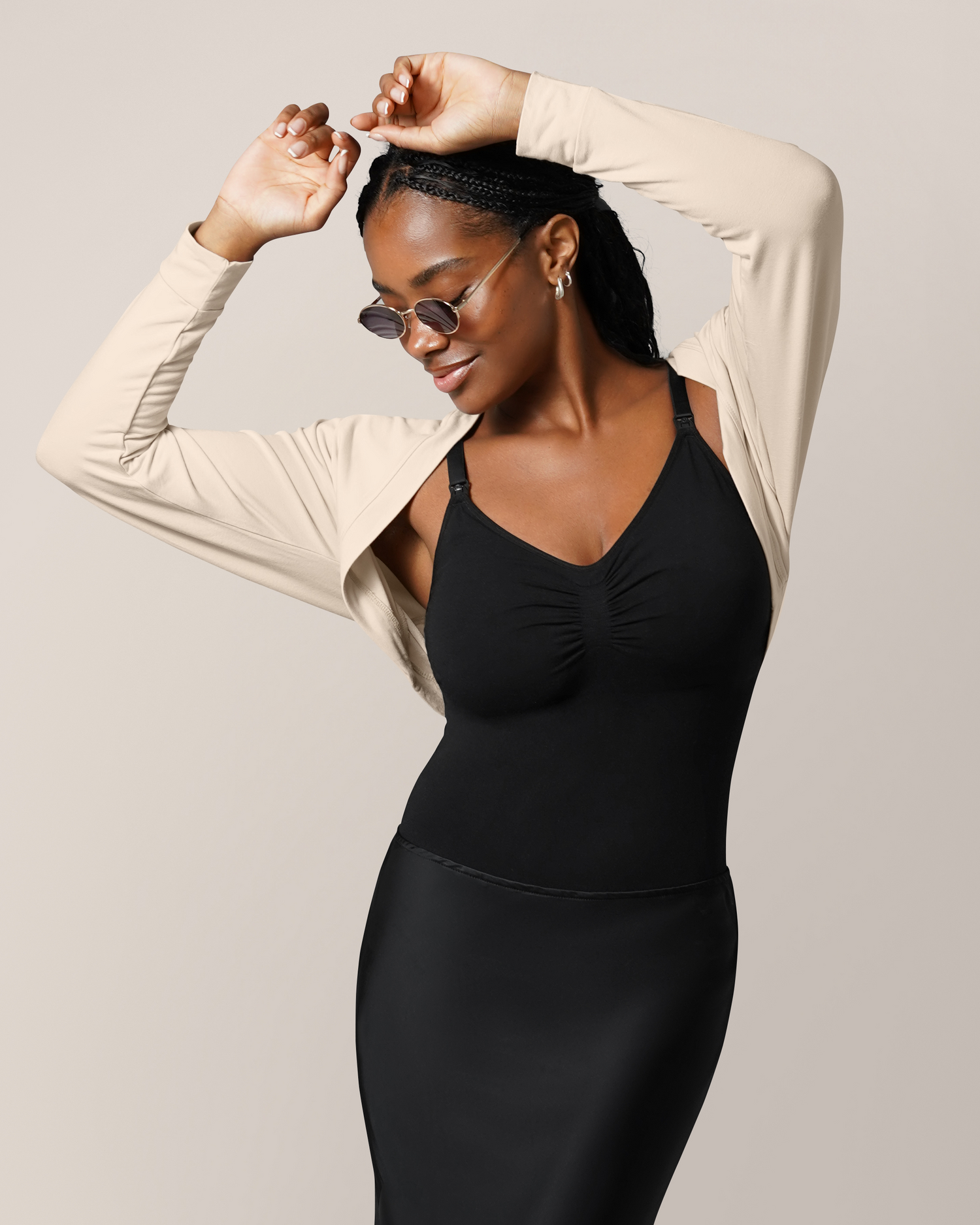 Front view of model with arms in the air wearing the French Terry Cardigan Shrug in Oatmeal, paired with our Sublime® Bamboo Maternity & Nursing Bodysuit and a black skirt