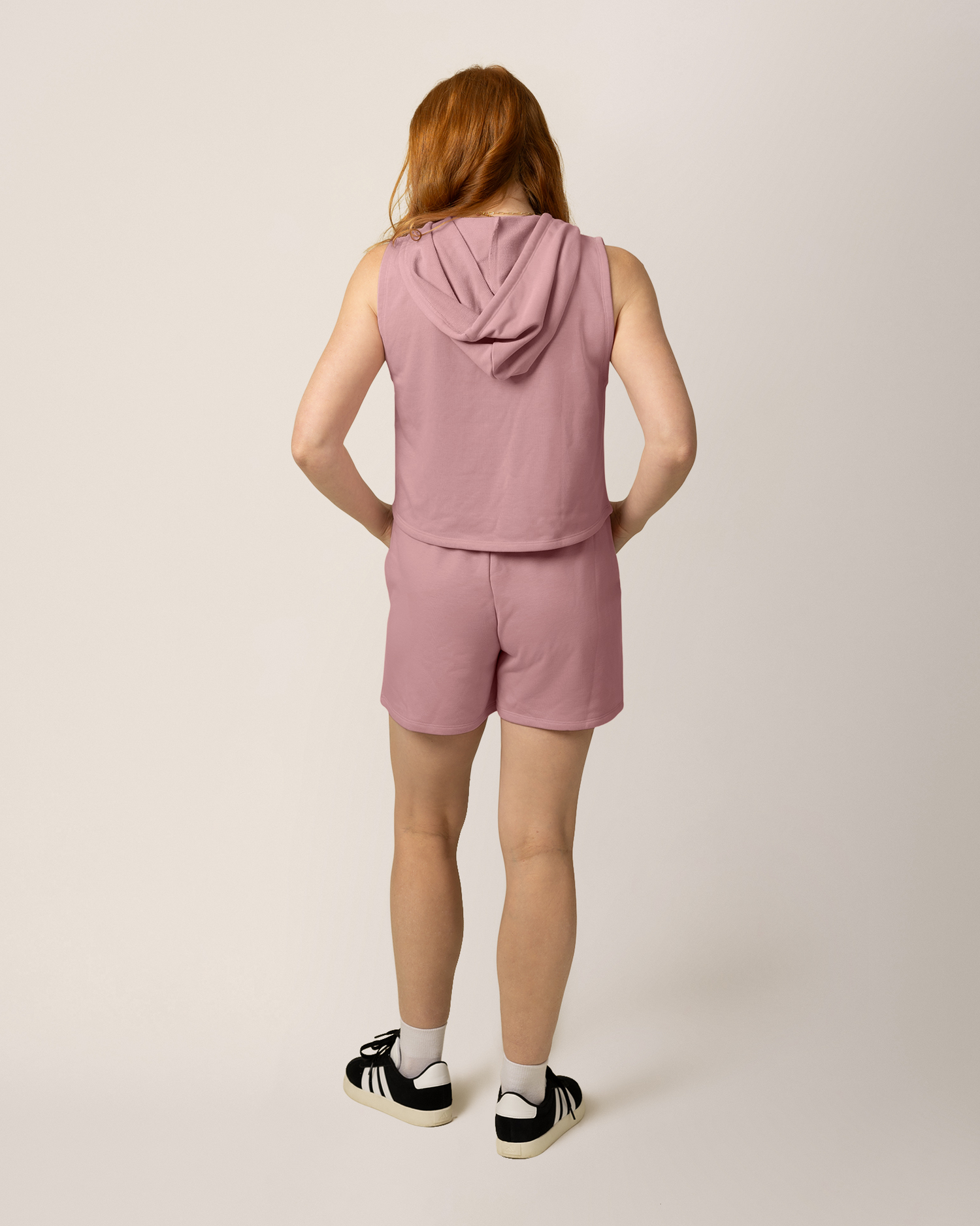 Back view of model wearing French Terry Sleeveless Nursing Hoodie in Light Mauve with matching French Terry On the Go Short