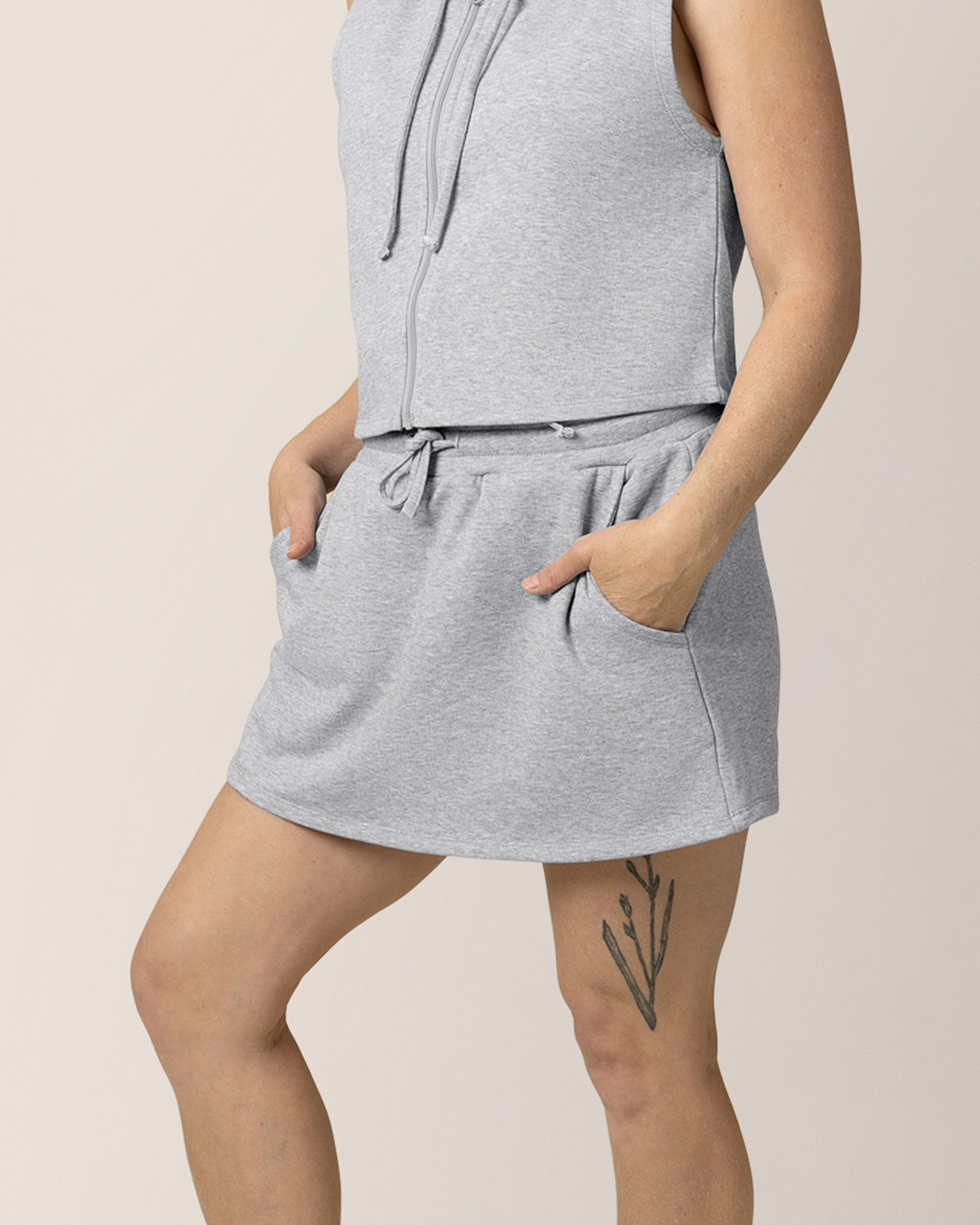 Front view of model wearing French Terry On the Go Skort in Grey Heather, with hands in pockets @model_info:Anna is wearing a Medium.