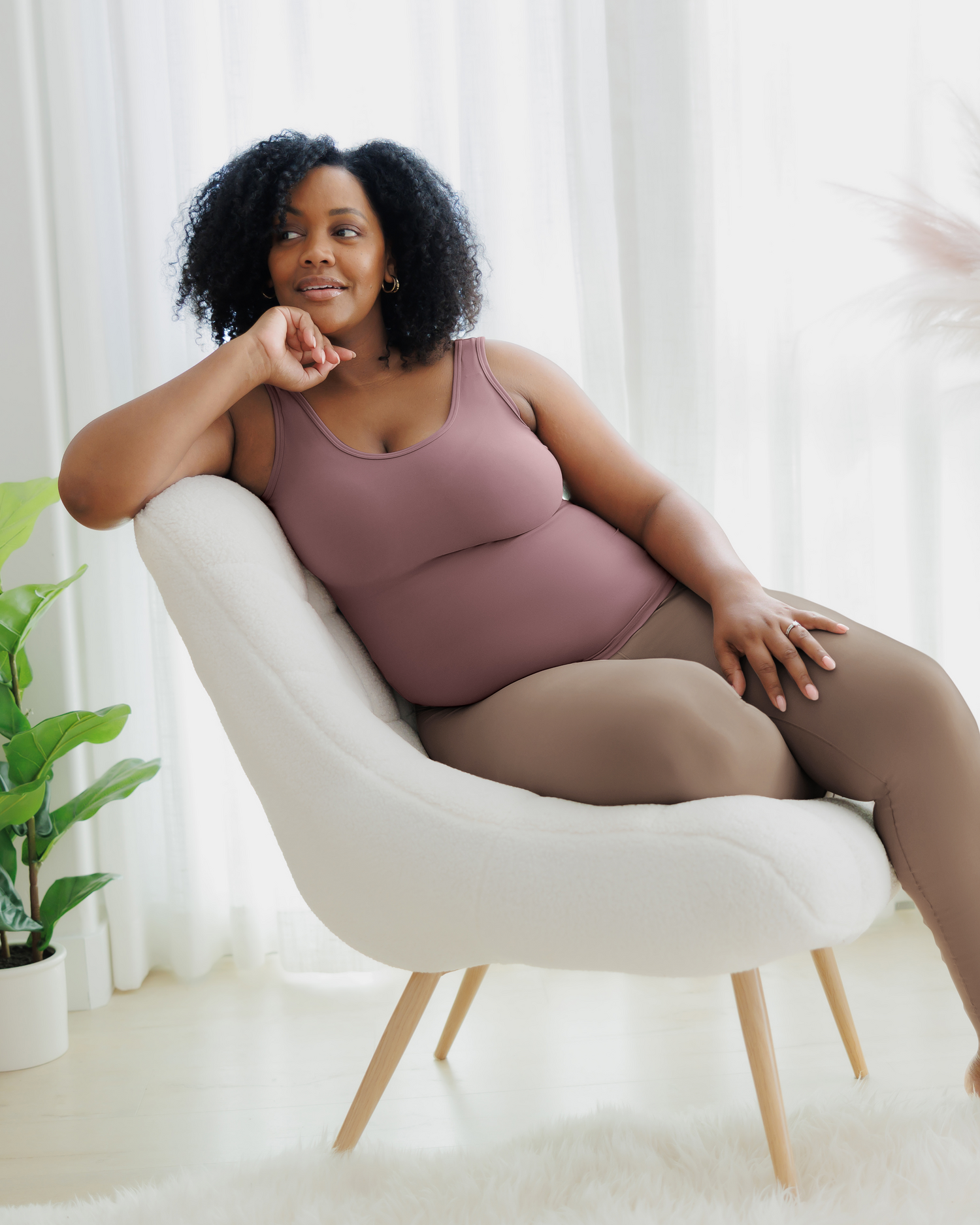 Model sitting in chair wearing the Grow with Me™ Maternity & Nursing Tank in Twilight, paired with Grow with Me™ Maternity & Postpartum Legging in Taupe