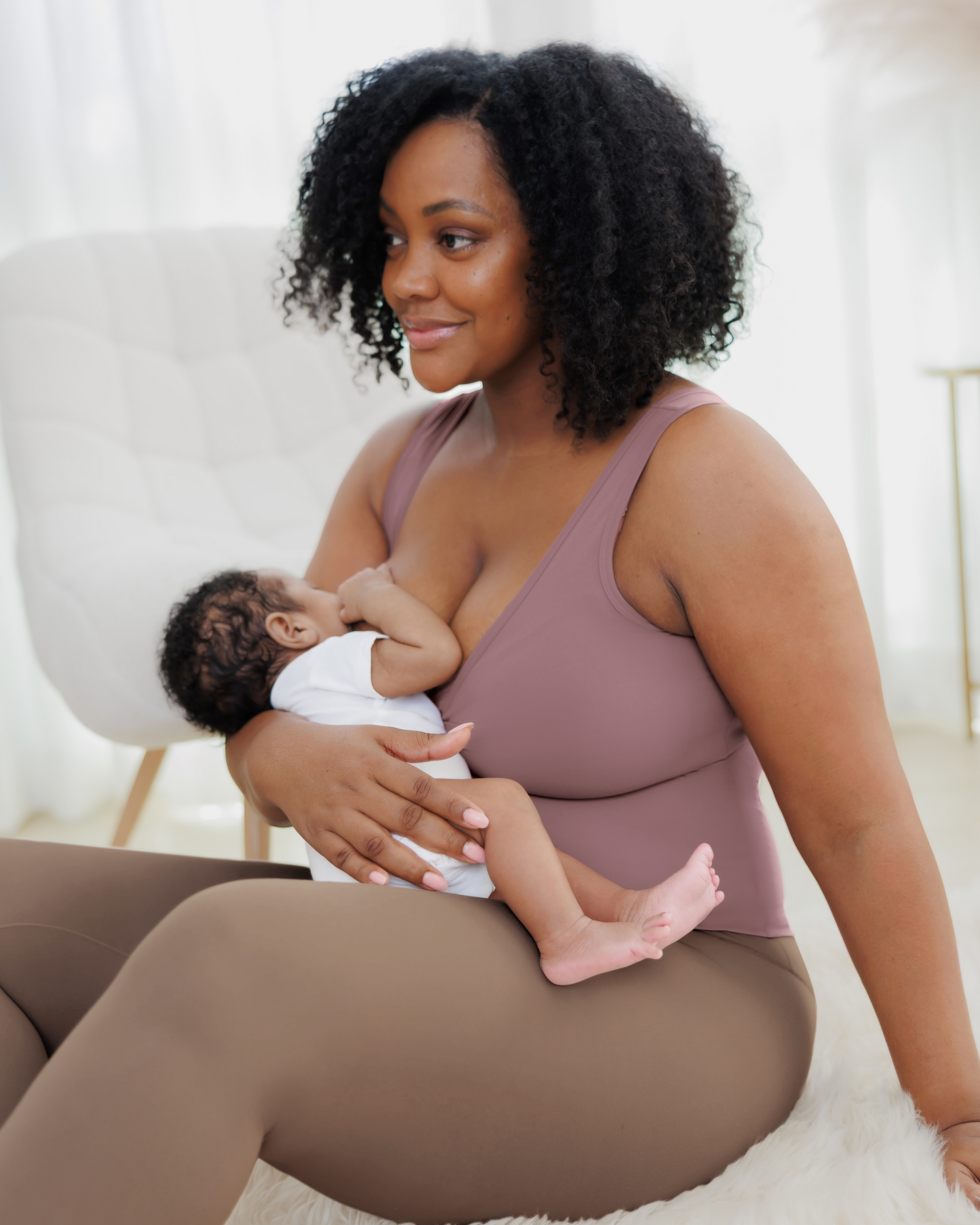 Model sitting and nursing baby, wearing the Grow with Me™ Maternity & Nursing Tank in Twilight, 