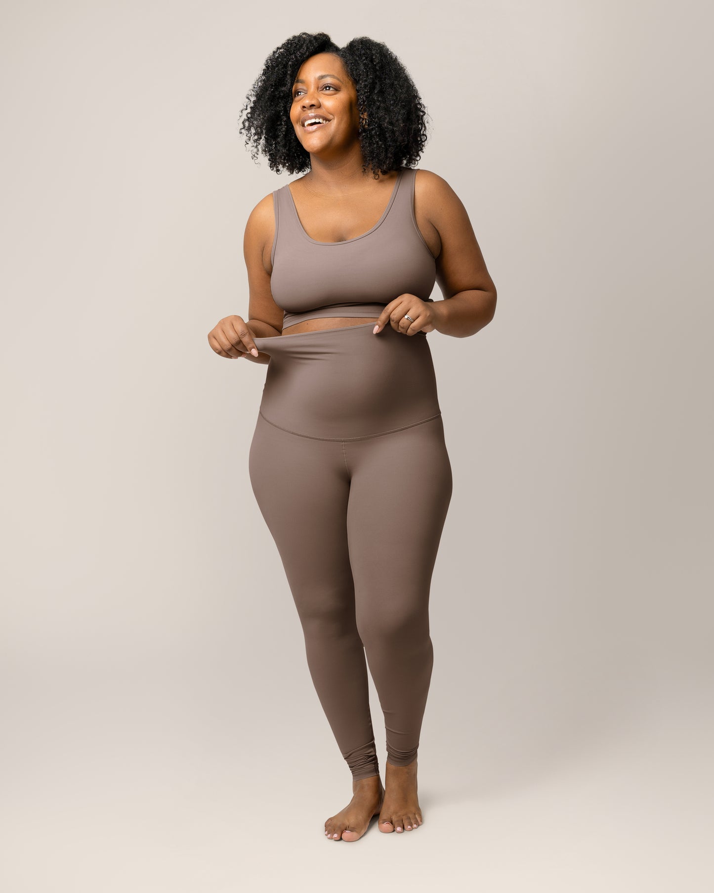 Close up of model wearing the Grow with Me™ Maternity & Postpartum Legging in Taupe, showing strech of the waistband. @model_info:Roxanne is 5'8" and wearing a Large.