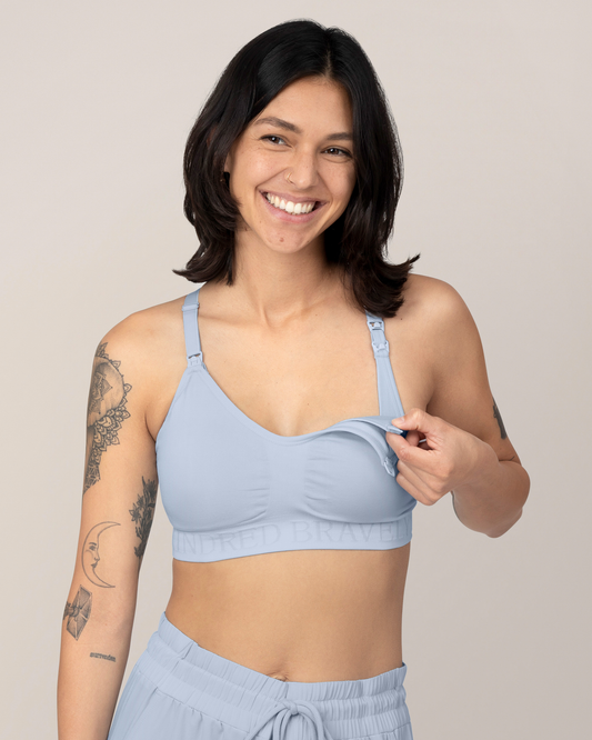 Front view of Model wearing the Sublime® Hands-Free Pumping & Nursing Sports Bra in French Blue while showing the clip down nursing functionality @model_info:Megan is wearing a Small.