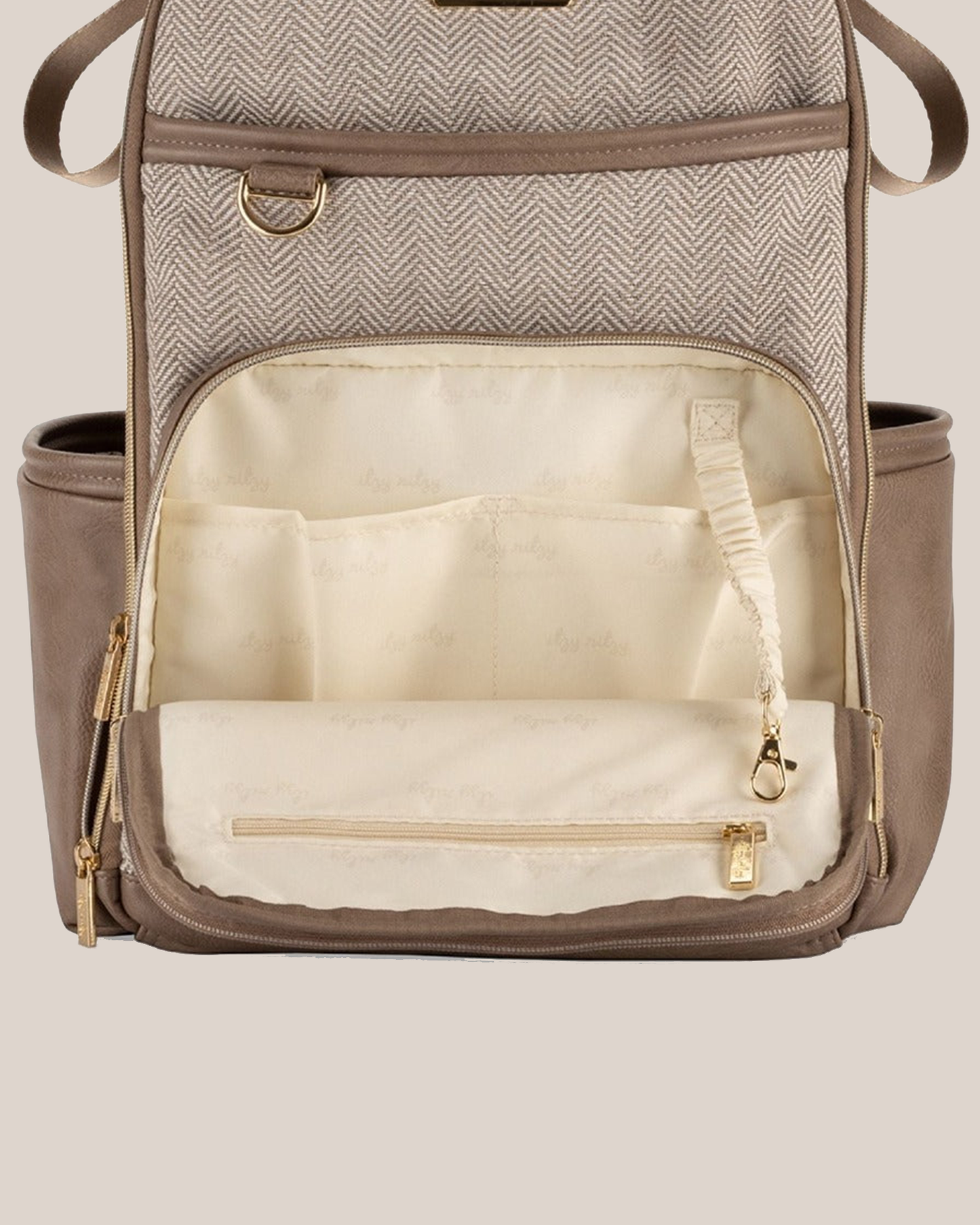 Front close-up view of the Itzy Ritzy - Boss Plus™ Diaper Bag Backpack in Vanilla Latte showing open front pocket