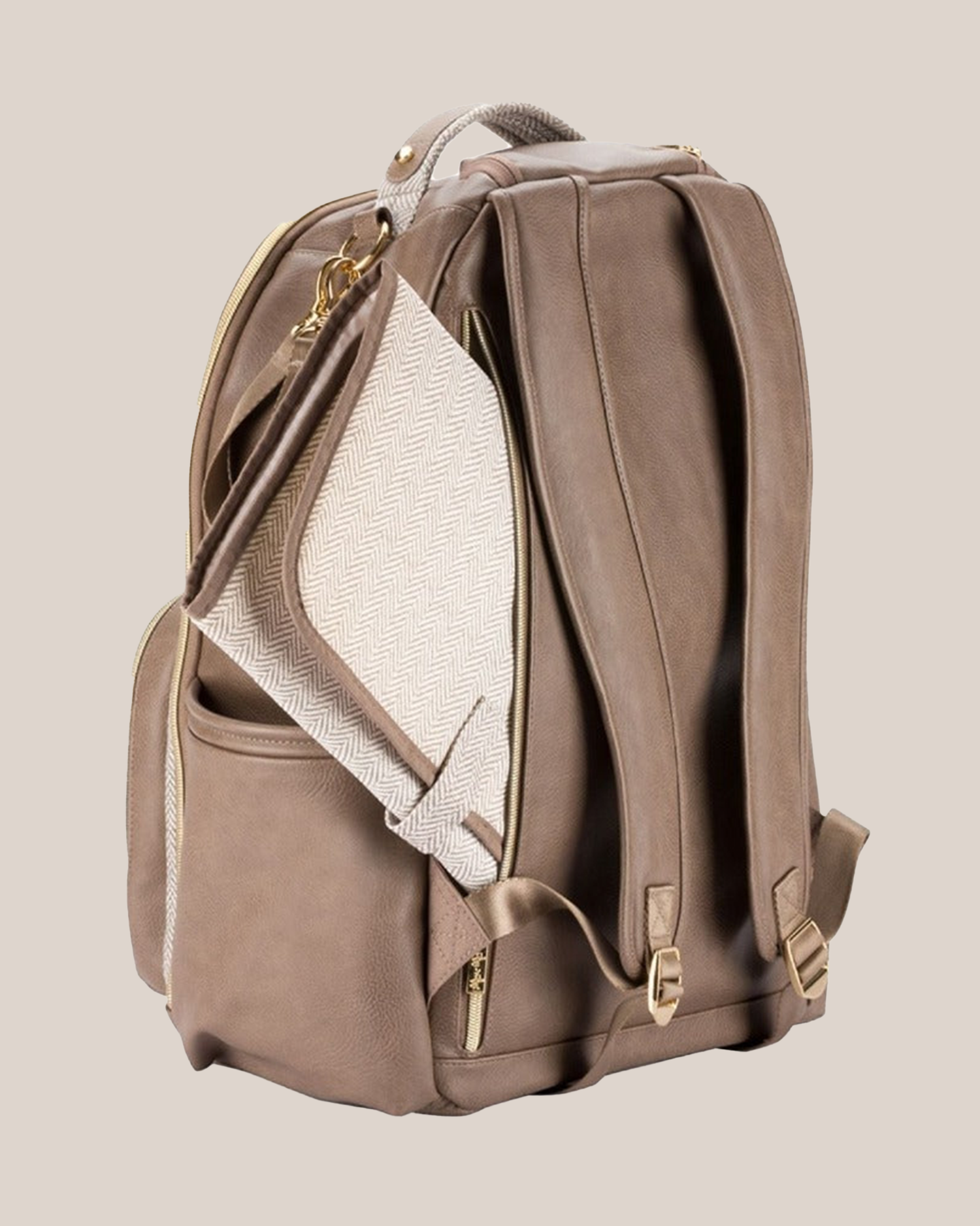 3/4 back view of the Itzy Ritzy - Boss Plus™ Diaper Bag Backpack in Vanilla Latte, showing changing pad and where it is stored