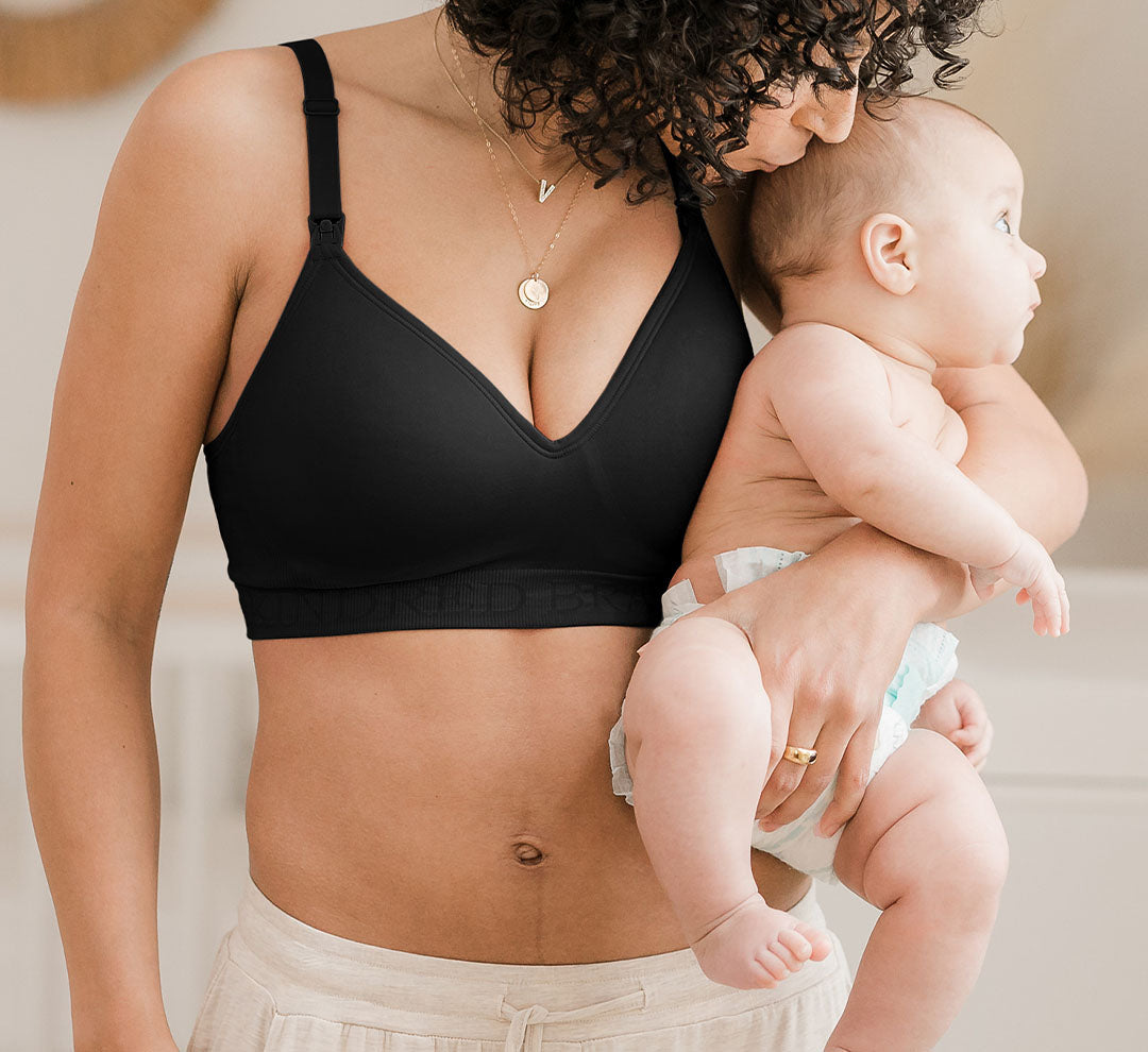 Model wearing the Signature Sublime® Contour Maternity & Nursing Bra in Black and holding baby