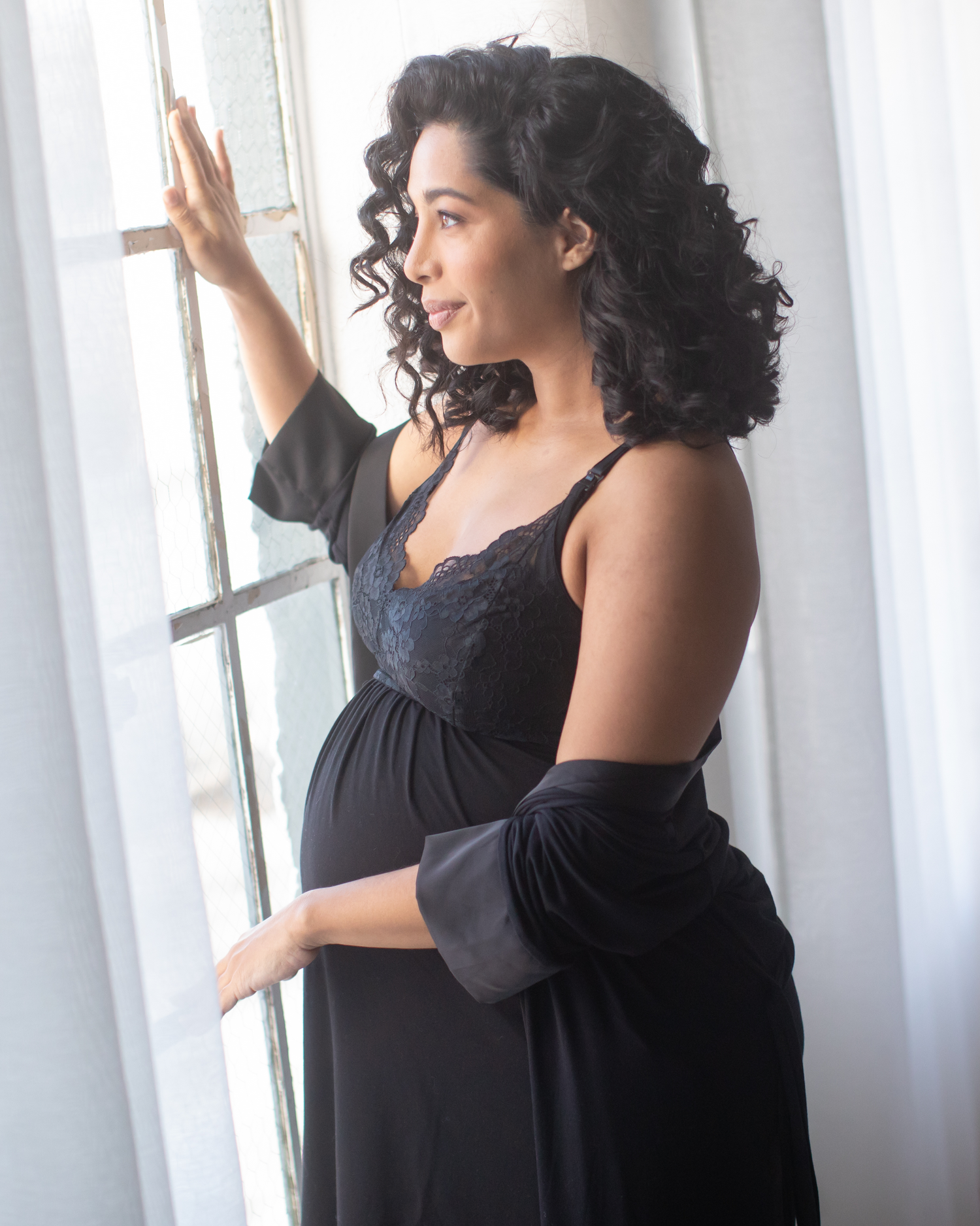 Side view of pregnant model wearing the Lucille Maternity & Nursing Nightgown in black, paired with matching Emmaline Robe.