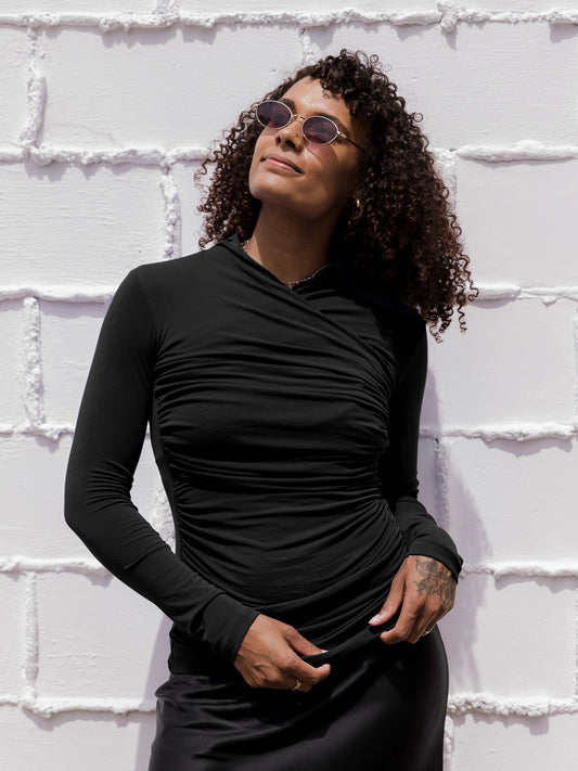 Front view of model outside wearing the Gianna Shirred Maternity & Nursing Top in Black. @model_info:Rudi is wearing a Small.