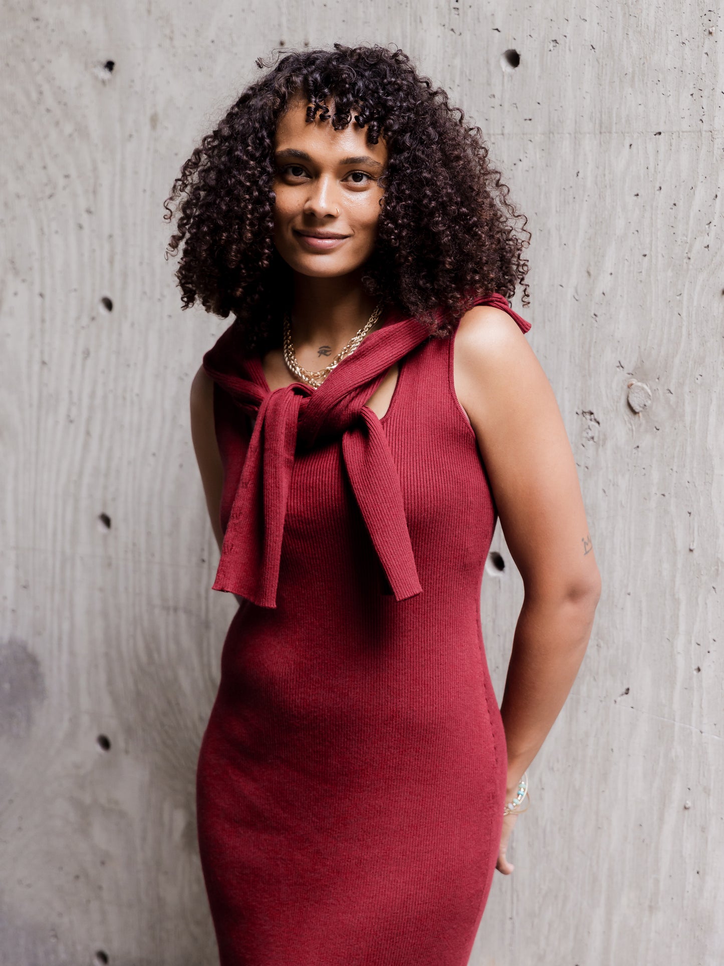 Front view of model wearing the 2-in-1 Maternity & Nursing Midi Dress in Garnet, with top long-sleeve cropped outer layer removed and tied around shoulders