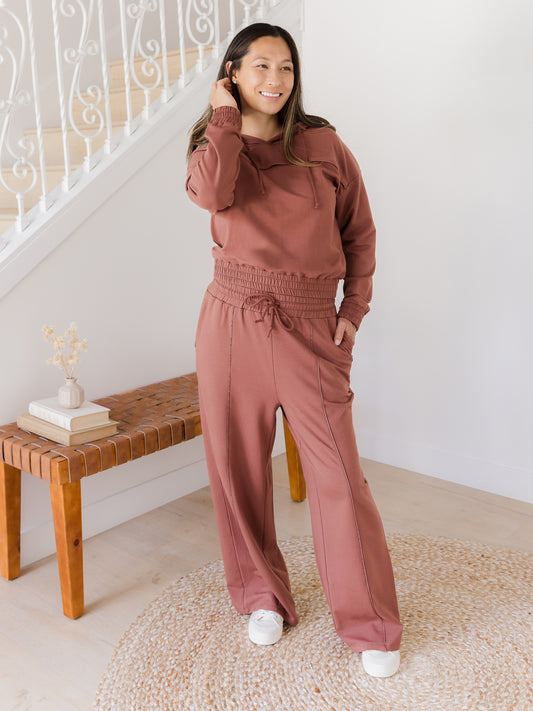 Full body image of model wearing the Mila High-Waisted Wide Leg Pant in Redwood with matching Mila Cropped Nursing Hoodie. @model_info:Joy is 5'7" and wearing a Medium Regular.