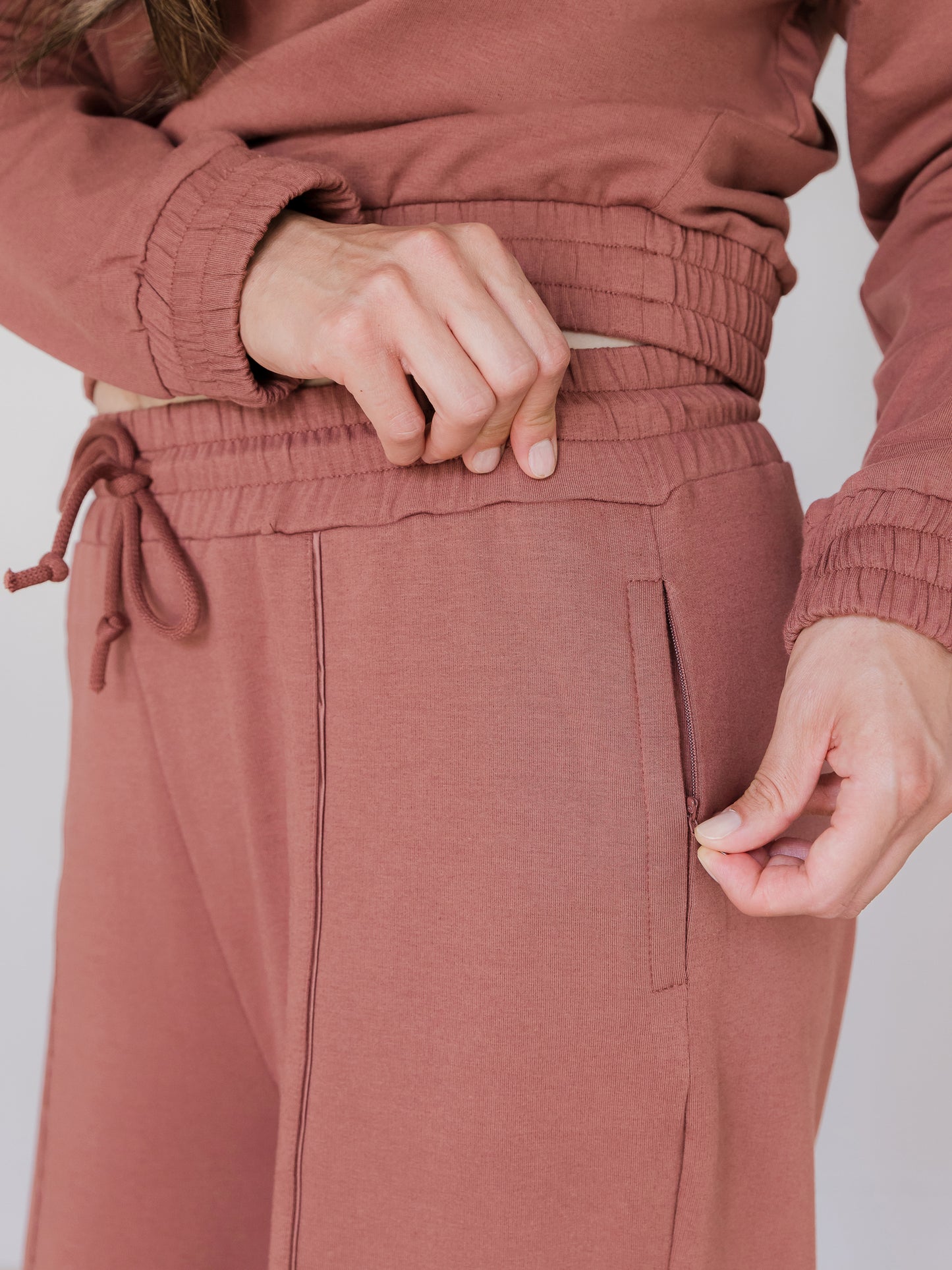 Close up of waistband and pocket with zipper on the Mila Wide Leg Pant in Redwood