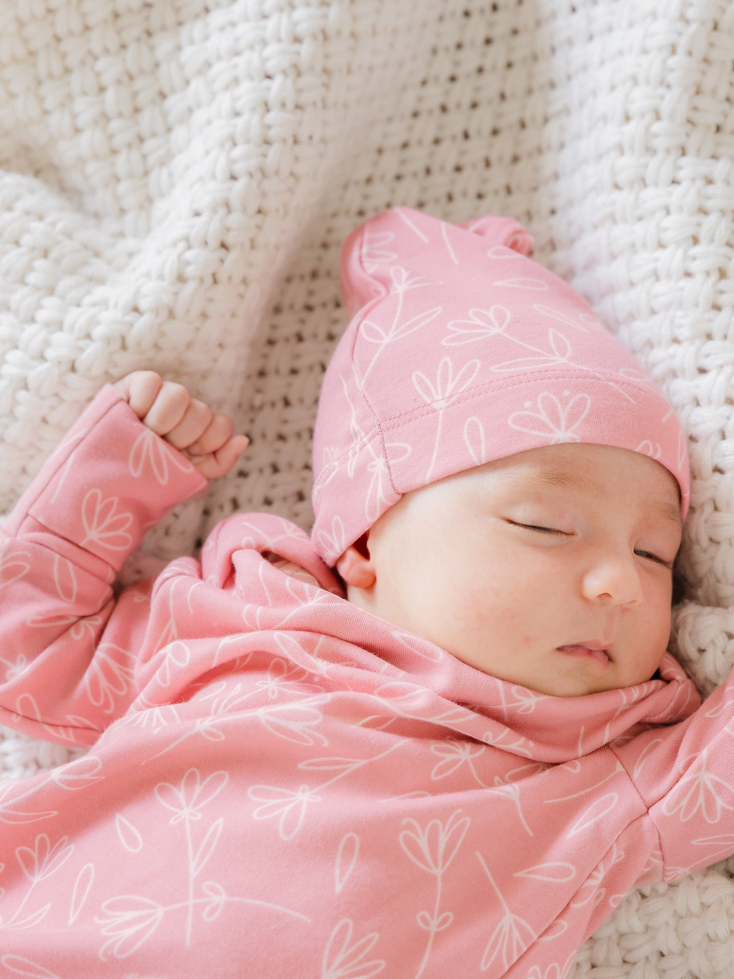 Close up of newborn wearing the Baby Knotted Gown & Hat Set in Pink Floral.