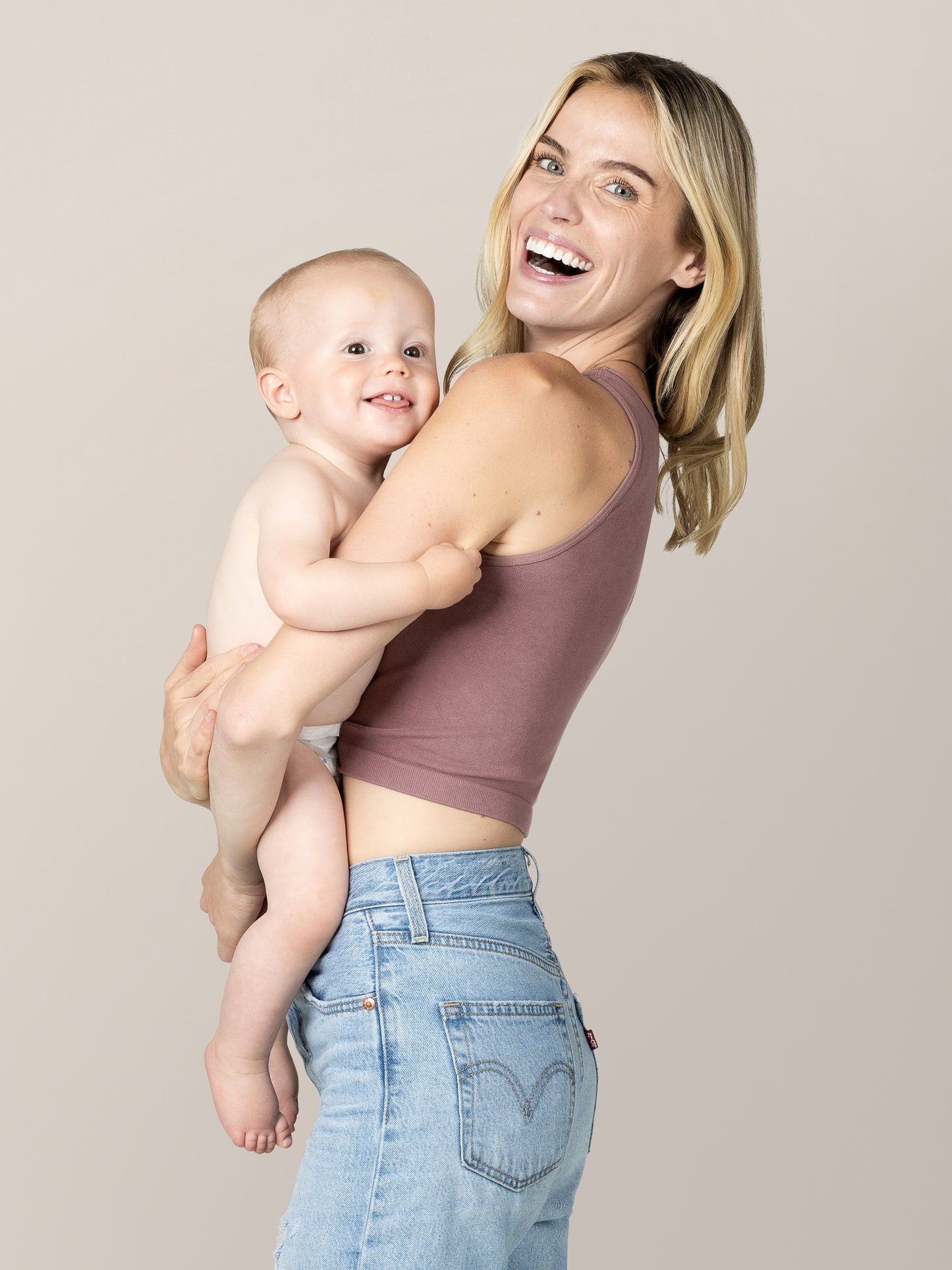 SIde view of pregnant model wearing the Sublime® Bamboo Maternity & Nursing Longline Bra in Twilight, holding babyl.