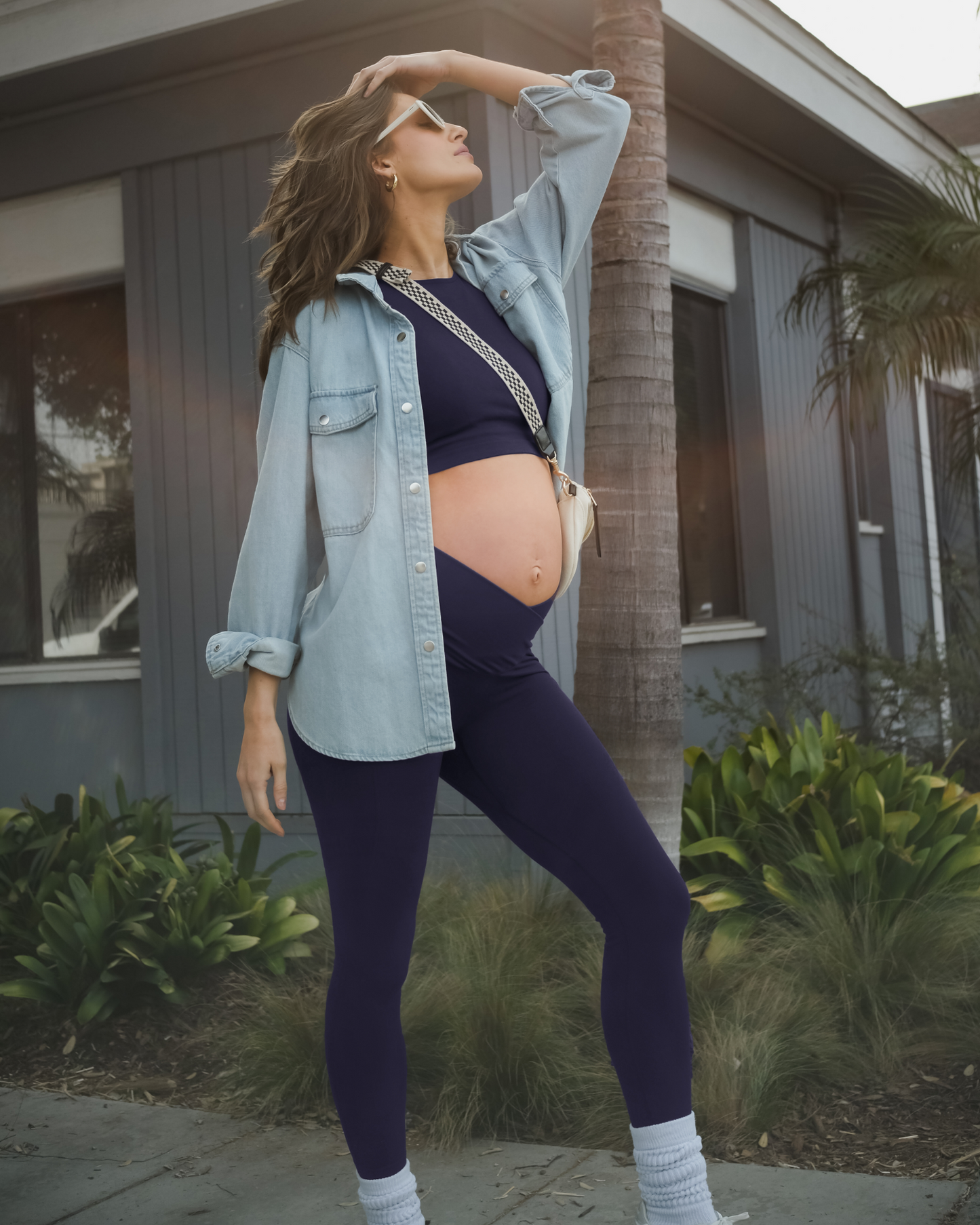 Full body angled view of model outside wearing the Sublime® Bamboo Maternity & Nursing Longline Bra Top in Navy, paired with matching Sublime® Bamboo Maternity & Postpartum Crossover Legging and open button down top