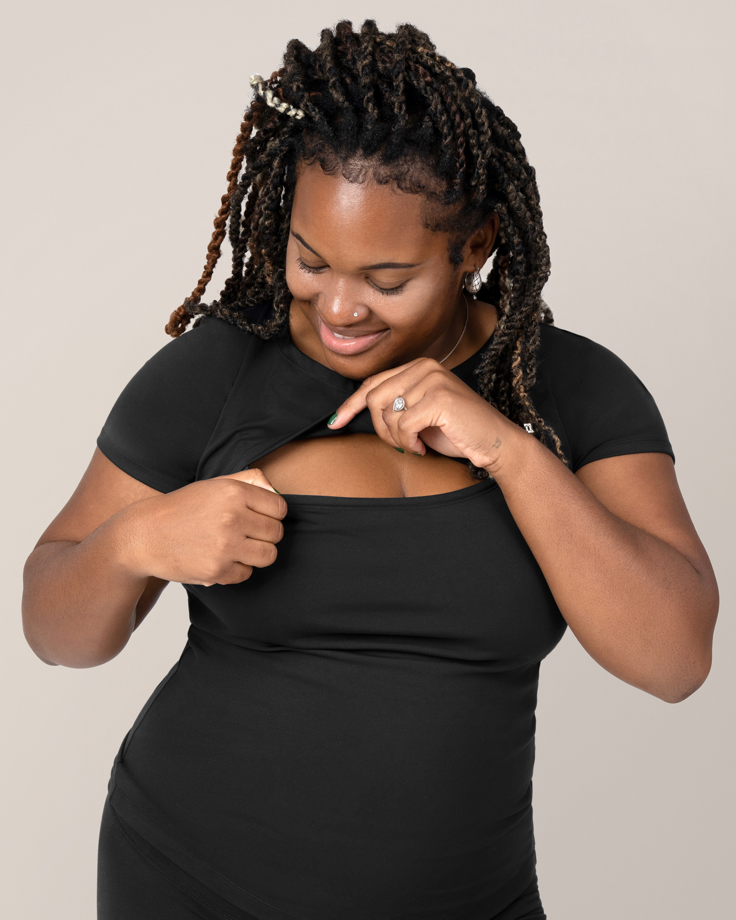 Front view of model wearing the Luna  Active Cut Out Nursing Top in Black while showing nursing access